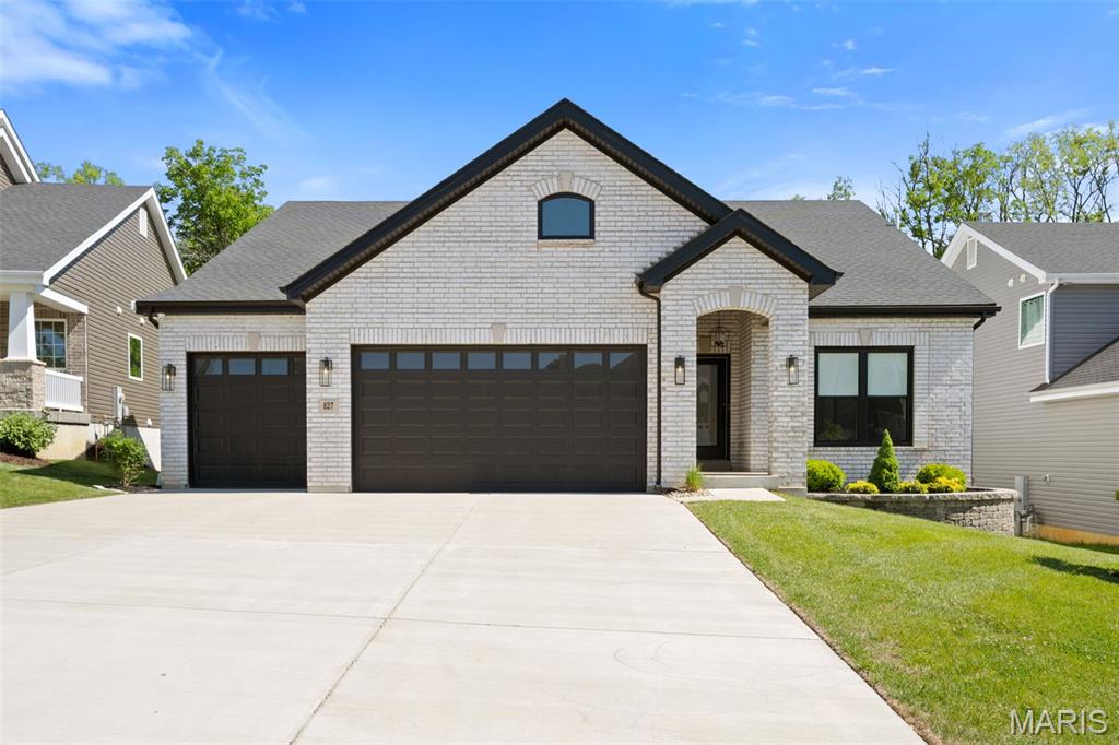 Exceptional curb appeal sets the tone for this exquisite ranch, showcasing a sophisticated white brick façade accented by bold black Pella windows and garage doors. Architectural gables, an elegant arched front porch, and professionally landscaped grounds create a warm yet refined welcome. The oversized three-car garage and expansive driveway provide both convenience and an impressive presence, making this home as functional as it is beautiful. This 3 bed 3.5 bath home offers so many upgrades and options for your luxury living. This expanded Maple floorplan offers 9 ft ceilings, a huge vaulted great room with custom stone façade over a gas direct vent 42” fireplace, engineered hardwood floors throughout the main level. Step into this breathtaking, light-filled chef’s kitchen, beautifully designed with both high-end functionality and sophisticated entertaining in mind. Shaker-style white cabinetry stretches to the vaulted ceiling, crowned by elegant, lighted glass-front display cases. Premium white quartz countertops provide endless prep space and flow into a generous central island with seating. Equipped with a suite of GE Cafe stainless steel appliances, this space is anchored by warm hardwood floors and bright recessed lighting, making it the undeniable heart of the home. Step into a stunning open-concept great room that blends modern sophistication with effortless comfort. Anchored by a sleek stone fireplace this space is designed for both everyday living and memorable gatherings. Rich engineered wood floors and a soft neutral palette create an elevated yet welcoming atmosphere, while the expansive layout seamlessly transitions into the gourmet kitchen for ideal flow. Recessed lighting and a contemporary chandelier illuminate the space with a warm, inviting glow, highlighting the clean architectural lines and thoughtful design choices throughout. Whether entertaining guests or enjoying a cozy night in, this great room delivers the perfect balance of style, comfort, and functionality—truly the heart of the home. Escape to the elegant primary suite, where spacious accommodations, warm hardwood floors, and oversized windows create a tranquil retreat. The thoughtfully designed custom walk-in closet features premium built-in cabinetry, abundant shelving, and dedicated storage, offering exceptional organization and style. Every detail has been carefully selected to provide a luxurious owner’s sanctuary. Exceptional lower level offering a beautifully finished living space perfect for relaxation and entertaining. This bright, open area features a spacious family room with recessed lighting and stylish neutral colors. The lower level also includes a private bedroom and a full bath, ideal for guests or extended living arrangements. With warm hardwood flooring, multiple seating zones, and direct access to the outdoor patio, this lower-level combines comfort, functionality, and refined design throughout.
Resort-style outdoor living awaits! The stunning composite deck with contemporary cable railing overlooks the beautifully landscaped backyard and provides the perfect space for entertaining or enjoying peaceful mornings outdoors. Below, the spacious covered paver patio creates a second outdoor living area with a ceiling fan, generous entertaining space, and seamless access to the walkout lower level. Curved landscape beds, mature greenery, and meticulous landscaping complete this private backyard retreat, offering the perfect balance of beauty, comfort, and functionality.