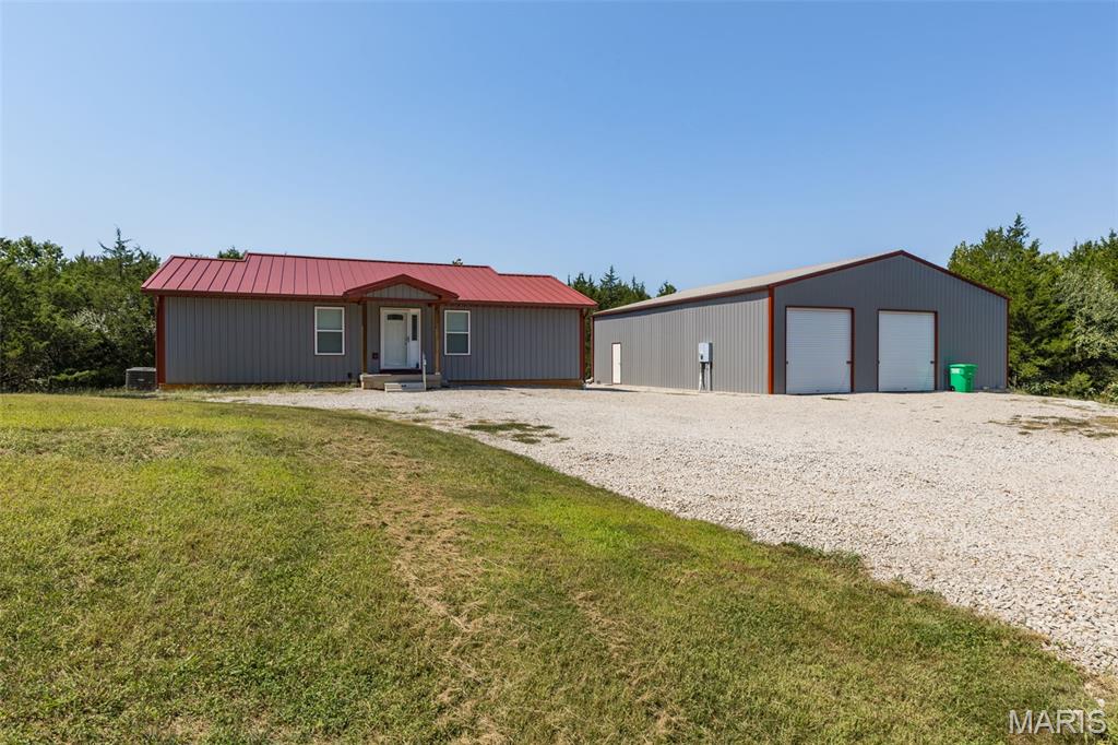 8.76 PRIVATE ACRES IN CADET, MISSOURI SHOWCASING NEWER HOME + HUGE POLE BARN "YOUR SPOUSES DREAM COME TRUE!" Discover the privacy, space, and peaceful country lifestyle you’ve been looking for on 8.76 beautiful acres in rural Washington County. Surrounded by mature trees, wildlife, this pristine property could easily be considered as owning your on slice of paradise. This gated property offers a secluded retreat with a newer home, abundant room to roam, with a massive pole barn ready for your vehicles, hobbies, equipment, or future plans. Gravel drive way leads to a welcoming 2-bedroom, 2-bath barn-dominium style home with tin roof, built less than five years ago giving you the comfort and efficiency of modern construction without the time, stress, and expense of building from the ground up. The open and welcoming main level features vaulted ceilings, abundant recessed lighting, ceiling fans, beautiful white doors and trim, and an open-concept feel perfect for everyday living and entertaining. The kitchen stands out with a large center island with added storage, custom cabinetry, farmhouse sink, stainless steel appliances, pull-out trash/recycling cabinets and a convenient Lazy Susan. The eat-in kitchen opens through sliding glass doors to an impressive full-length covered back deck, offering the perfect spot to relax, entertain, or take in the peaceful  and private surroundings. The deck could easily be screened in for a more comfortable outdoor entertaining space if desired. The two spacious bedrooms are thoughtfully located on opposite ends of the home, offering privacy for family members or guests. Both bedrooms are served by their own full bathrooms featuring walk-in showers and on suite includes a generous size walk in closet to boot. The unfinished lower level provides tremendous potential for additional living space! With 10-foot ceilings, two egress windows, and walkout, there is plenty of room to create a family room, additional bedrooms, home office, recreation area, or whatever your needs may be. This large space comes with your own private safe area under the front porch, making it ideal for a storm shelter, storing hunting gear, or work area. A full-length concrete patio provides even more usable outdoor space beneath the deck. The perfect space and atmosphere for that individual who loves or enjoys a hot tub year round with privacy in mind. Bonus, pole barn/barn dominium-style building, separate from the home! Pole Barn includes two large garage doors with side entry that could easily accommodate an RV, storing vehicles, boats, recreational equipment, toys, a workshop, hobbies, or a home-based business with loft area for added storage. It has endless possibilities. Additional features include well and septic, water softener, ceiling fans throughout, recessed lighting, vaulted ceilings, gated entrance, acreage, and plenty of room to make the property your own. The backyard offers numerous possibilities for gardening, recreation, animals, entertaining, or simply enjoying the peace and quiet of country living. Nearest towns are approx. 15 minutes to Potosi or De Soto with easy access to Highway 21 and located in the Kingston School District. This is truly rural living without feeling too far from the conveniences of the real world and recreational fun you've been searching for. Conveniently located approx. 5 miles of the Mineral Fork and Big River. What's not love? If you’ve been dreaming of getting away from the hustle and bustle of city living and having a place that feels like your own private retreat, this could be it! Your getting the benefits of a newer home without having to wait for the hassle of building it yourself. Come take a look and discover everything this unique property has to offer! Call for your personalized tour today. This is a must see and a one of a kind find!