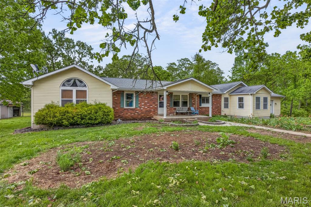 Set on 5.43 scenic acres in Bismarck, this exceptional property offers space, comfort, and standout features throughout—perfect for horses or hobby farming. The home boasts over 2,200 sq ft on the main level with an inviting entry foyer, built-in shelving, and an open floor plan ideal for everyday living and entertaining. The kitchen is a showstopper with custom cabinetry, center island, pantry, gas range, and chef-style hood. Enjoy both a formal living room and a cozy family room with gas fireplace, plus a bright sunroom overlooking the property.  The spacious master suite features dual walk-in closets, and main floor laundry adds everyday convenience. A partially finished basement provides the possibility of a 3rd bedroom with additional living or storage space.  Step outside to a covered deck with an outdoor fireplace, perfect for relaxing or hosting. Equestrian-ready amenities include a 46x18 barn with two horse stalls, tack room, and workshop/storage area, plus an additional large 40x40 barn. A roughly 1-acre pond and greenhouse complete this versatile property. An attached garage rounds out this incredible opportunity for country living. NEW ROOF AND GUTTERS are being installed!