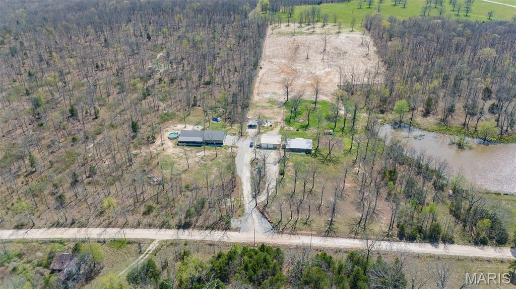 Discover the perfect blend of space, versatility, and modern living with this exceptional 19.58-acre property m/l featuring two newer homes (built in 2020 & 2022). Offering a total of 6 bedrooms and 4 bathrooms, this unique setup is ideal for multi-generational living, an income-producing investment, or the ultimate homestead lifestyle. The land showcases a desirable mix of open pasture and wooded acreage, perfect for livestock, recreation, or hunting. The property is well-equipped with multiple outbuildings, shops, garages, and carports—providing ample space for equipment, hobbies, or business use. Two generously sized garages add even more functionality. Enjoy outdoor living with an above-ground pool with a deck and a playground area, creating a great space to relax and entertain while taking in the peaceful surroundings. Both homes share a well and driveway, with lagoon systems in place, offering practical and efficient rural living. Just a short drive to Montauk State Park, Scenic Riverways, multiple conservation areas, and Mark Twain National Forest, this property is ideal for the avid outdoorsman. Whether you’re looking to spread out, generate rental income, or create your own private retreat, this property offers endless possibilities. See MLS# 26023176 and MLS# 26023161 for separate listings