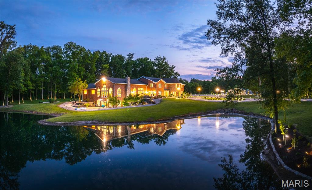 This exceptional property offers the perfect blend of luxury, privacy, and recreation—all just minutes from town. Set on 14 beautifully maintained acres, it features a stocked pond, saltwater pool, and lush landscaping that gives the estate a resort-like feel. Inside, the spacious chef’s kitchen is designed for entertaining, while large windows flood the home with natural light. The private primary suite provides a quiet retreat, and an indoor gym with a basketball court adds even more to enjoy year-round. Two garages and a large pole barn offer ample storage for vehicles, equipment, or hobbies. Conveniently located just 30 minutes to Edwardsville and 45 minutes to St. Louis, this property truly has it all.