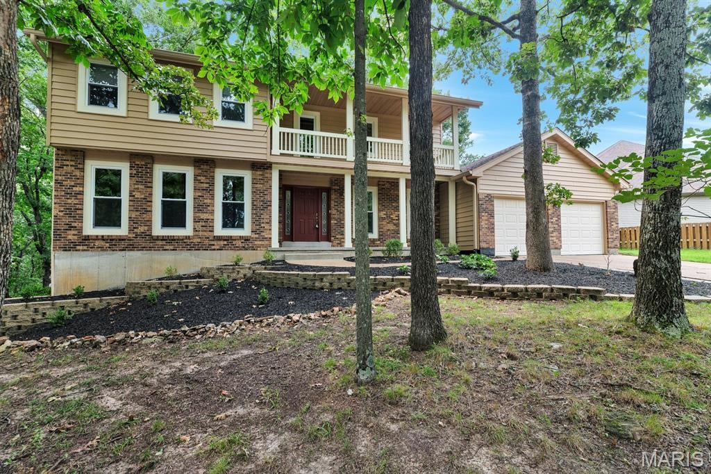 Nestled among the treetops in the Lockmoor section of Paradise Valley, this graciously proportioned two-story offers an inviting blend of space, character and nature, with the conveniences of suburbia just minutes from Highway 44 and Gravois Bluffs. Mature trees create a picturesque backdrop for this 4+ bedroom home, where hardwood floors extend throughout much of the living and bedroom areas. The main level offers an eat-in kitchen, formal dining room, living room, family room, main-floor laundry and a versatile bonus room well suited for an office, playroom or guest space. Upstairs, the spacious primary suite features a large walk-in closet and private bath with walk-in shower. Another bedroom opens to a charming covered second-story balcony and offers an additional oversized walk-in closet. Outdoor living is a highlight with an expansive vaulted three-season screened porch overlooking the wooded surroundings, plus adjoining low-maintenance decking. The walkout lower level offers substantial unfinished space ready to accommodate future recreation, living or sleeping areas. With generous room sizes, flexible spaces and a beautiful wooded setting, there is plenty here to enjoy now and endless opportunity to personalize over time.