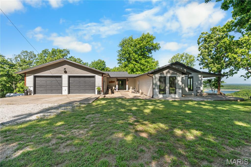 Experience elevated lakefront living on the shores of Bull Shoals Lake, where panoramic views and direct lake access create an exceptional Ozark retreat. This thoughtfully updated 3-bedroom, 3-bath residence offers refined comfort and versatility, featuring two bonus rooms ideal for guests, private office space, or recreation, along with a dedicated storm shelter/safe room. Extensive upgrades enhance both style and function, including newer Andersen windows, updated siding and exterior finishes, and a beautifully added kitchen with a coffee bar designed for gathering and entertaining. The home is supported by modern conveniences such as fiber optic internet, a private well, water softener, and a whole-home generator for peace of mind. Major systems--including roof and HVAC--have been recently updated, reflecting pride of ownership throughout. Step outdoors to a premium Trex deck, perfectly positioned to capture sweeping lake views and tranquil surroundings. A 4x4 path provides direct access to the shoreline, while the detached shop with a wood stove adds both functionality and flexibility. The lower level, already plumbed for a second kitchen, offers additional potential for extended living or guest accommodations. Ideally located just minutes from Peel Ferry, marinas, and lakeside dining, this property presents a rare opportunity to enjoy luxury, privacy, and the natural beauty of Bull Shoals Lake in one exceptional offering.