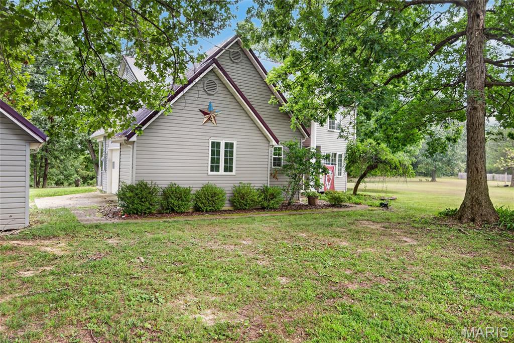 Space, character, and room to breathe! Situated on approximately 1 acre, this beautiful 4-bedroom, 2.5-bath home offers a unique floor plan filled with natural light and timeless charm. The stunning two-story living room features soaring ceilings, expansive windows, and hardwood floors, creating an inviting space for gathering with family and friends. The updated kitchen showcases butcher block countertops, a farmhouse sink, stainless steel appliances, double ovens, and abundant cabinetry, while the adjoining dining area opens to the spacious wraparound deck—perfect for entertaining or enjoying peaceful evenings outdoors. Upstairs, the open loft provides a flexible space for a home office, reading nook, or play area. The generous primary suite includes a private bath, and three additional bedrooms offer room for everyone. Outside, you'll appreciate the attached 2-car garage, detached 1-car garage/workshop, mature shade trees, and plenty of open yard to enjoy. If you've been searching for a home with space, character, and a peaceful setting, this one is ready to welcome you home.
