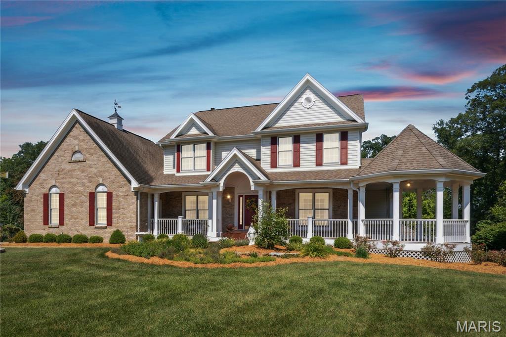 New Upgrades Have Been Made At This Elegant Executive-Style Home on 5.51 Acres with Outbuilding and 14-Acre Stocked Subdivision Lake! This newly updated Southern Living-style home offers luxury and charm in a stunning setting. You are greeted with a wraparound front porch with a gazebo—perfect for relaxing or entertaining. A spacious foyer is flanked by formal living and dining rooms and opens to a large great room with a cozy fireplace. The newly updated kitchen offers quartz countertops, 42” cabinets, a center island, stainless steel appliances, new lighting, and updated hardware. A vaulted sunroom off the breakfast room opens to two covered decks, ideal for enjoying the peaceful surroundings. A mudroom leads to a large main-floor laundry. The main level also includes a guest bedroom and full bath. Upstairs, a welcoming loft leads to the spacious primary suite with two walk-in closets and an updated, luxurious bath. Two additional bedrooms, each with private updated baths, complete the upper level. The finished walkout lower level features a family room with fireplace and wet bar, rec room, full bath, and lots of storage. Upgrades include, new Quartz counters, updated light fixtures and fans plus new flooring in bathrooms! Outside, enjoy a 26x36 outbuilding with an upper-level bonus room. Relax by the charming shed with patio and a koi pond. You will also love access to the 14-acre subdivision lake. This is a truly remarkable home you’ll want to make your own!