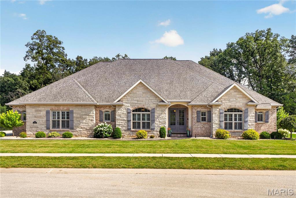 **Exquisite Custom Estate on a Wooded Cul-de-Sac Lot!** This extraordinary 5-bedroom, 4-bath CUSTOM RANCH showcases exceptional craftsmanship, timeless design, and an unmatched combination of luxury, comfort, and versatility. This remarkable residence offers garage space for up to 10 vehicles—an exceptional amenity for collectors, hobbyists, or those seeking the ultimate workshop. The thoughtfully designed OPEN FLOOR PLAN is highlighted by soaring vaulted ceilings, rich hardwood flooring, and a spectacular floor-to-ceiling stone fireplace that anchors the impressive great room. The gourmet kitchen is beautifully appointed with an expansive center island, custom cabinetry, double convection ovens, premium vent hood, Butler's pantry, and designer organizational features, creating a space that is as functional as it is elegant. The MAIN LEVEL offers four spacious bedrooms, including a luxurious primary suite, three beautifully finished baths, and an oversized laundry room with built-in workspace. The walk-out finished LOWER LEVEL is an entertainer's dream, featuring a private home theater, second kitchen, recreation room, bonus room, custom executive office/cigar room with separate exhaust fan, fifth bedroom, full bath, and abundant storage—perfect for hosting guests or multi-generational living. Step OUTSIDE to your own private resort, where a stunning custom pavilion with a grand wood-burning fireplace, gas fire pit, covered screened deck, stamped concrete patio, hot tub, and tranquil wooded backdrop create the ultimate setting for year-round entertaining and relaxation. Every DETAIL has been carefully considered, including geothermal heating and cooling, heated garages with radiant-heated epoxy floors, workbenches, a climate-controlled lower garage with mini-split HVAC, gutter guard, irrigation system, professional landscape lighting, whole-home audio, outdoor speakers with Disney experience, custom roofline lighting, an integrated security system with cameras, and Control4 Home Automation system. Located in one of O'Fallon's most desirable neighborhoods, just minutes from vibrant downtown O'Fallon and Scott Air Force Base, this exceptional residence offers an unparalleled blend of sophistication, privacy, and modern convenience. A truly rare opportunity to own one of the area's finest custom homes. Ask to see the features sheet for more details!