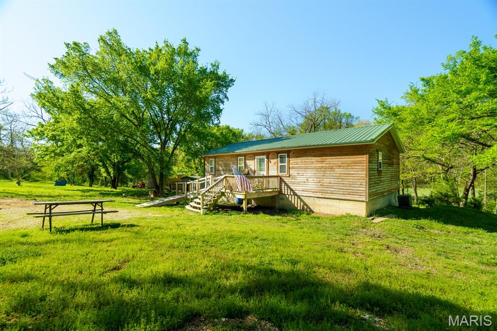 At the end of a private road, finds this sweet home with a Full walkout basement and backing up to NATIONAL FOREST.  Just down the road on State Hwy E is the confluence of the Huzzah Creek and the Courtois Creek great for floating, fishing or just a fun day in the Creek + Missouri State Forestry land too.  But if that is not enough than this will grab your attention, this property is very secluded with wildlife abundant and privacy your privilege.  Just let someone try and find you!  The home is darling with great use of space.  Raw lumber flooring in plank style has been coated and fits that country tone you love.  There is tons of storage and a bedroom and bath in the walkout basement just crying for decor to match that wood design features.  Primarily wooded, it does offer a strip of Pastureland. If Localvore is in your future plans, this will answer a lot of the requirements you might have.  There is a nice detached garage/shop building waiting for your vehicle or hobbies. See you soon!
