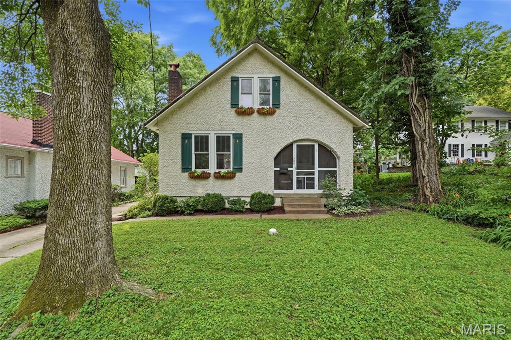 Charming Webster Groves cottage with nearly 100 years of history, charm, and stories waiting to be told! From the moment you step onto the screened-in front porch, you’ll appreciate the inviting personality this home offers. It’s the perfect place to enjoy your morning coffee or unwind at the end of the day!
Inside, hardwood floors, crown molding, a cozy wood-burning fireplace, and built-in bookshelves add warmth and character throughout the home. The main level offers a spacious living room, dining area, and kitchen with pantry, plus a convenient bonus room/drop zone.. Two bedrooms and a full bath complete the main floor.
Upstairs, the private primary suite feels like its own retreat with a spacious bedroom, 4 closets, additional linen storage, and a full bath. Separate heating and cooling upstairs provide year-round comfort.
Important updates include a newer AC & mini-split system (2022), appliances (2021), water heater (2023), and electrical panel in the detached garage (2021). Most windows have been replaced with vinyl windows for added efficiency.
Outside, enjoy a back deck and a detached 2-car garage with additional storage. The garage is equipped with its own EV charging station, making it ready for today’s lifestyle.
Located in the heart of Webster Groves, this home offers the charm buyers are searching for with the convenience of being close to shops, restaurants, parks, and everything this community has to offer. A true gem — don’t miss your chance to call it home!