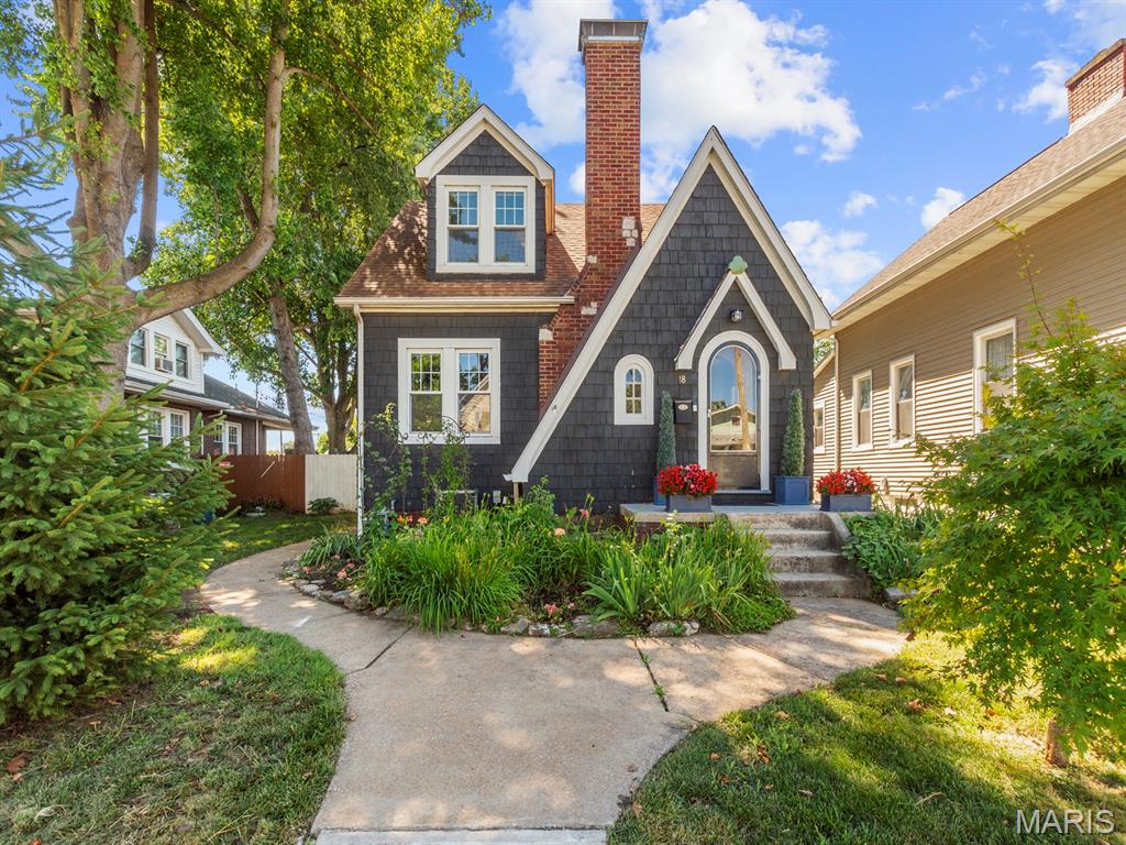 Fall in love with the storybook charm of this beautifully maintained home. Featuring distinctive architectural details including a rounded front door, leaded glass window, dormer windows, a stately brick chimney, and rich dark exterior siding accented by crisp white trim, this home is truly one of a kind. Inside, you'll find beautiful original hardwood floors and a charming open staircase that enhance the home's timeless character.

The main level offers a spacious living room, formal dining room, updated kitchen with modern cabinetry, and a bright sunroom—the perfect spot to enjoy your morning coffee while overlooking the beautifully landscaped, fully fenced backyard. Upstairs features two bedrooms and a full bath, while the finished basement provides additional living space, a full bathroom, laundry area, abundant storage, and potential for an unofficial bedroom, home office, or family room.

Outside, a curved sidewalk welcomes guests through thoughtfully landscaped gardens bursting with seasonal color, while mature trees provide shade and privacy. The backyard retreat includes a brick patio ideal for entertaining and a detached garage. Combining character, curb appeal, and timeless style, this exceptional home offers a truly inviting place to call your own.

Conveniently located near shopping, dining, schools, public transportation, and major interstate highways, this home offers the perfect combination of comfort, convenience, and accessibility. Buyer to independently verify all listing information, including but not limited to square footage, room measurements, features, lot size, taxes, exemptions, schools, and other pertinent details.
