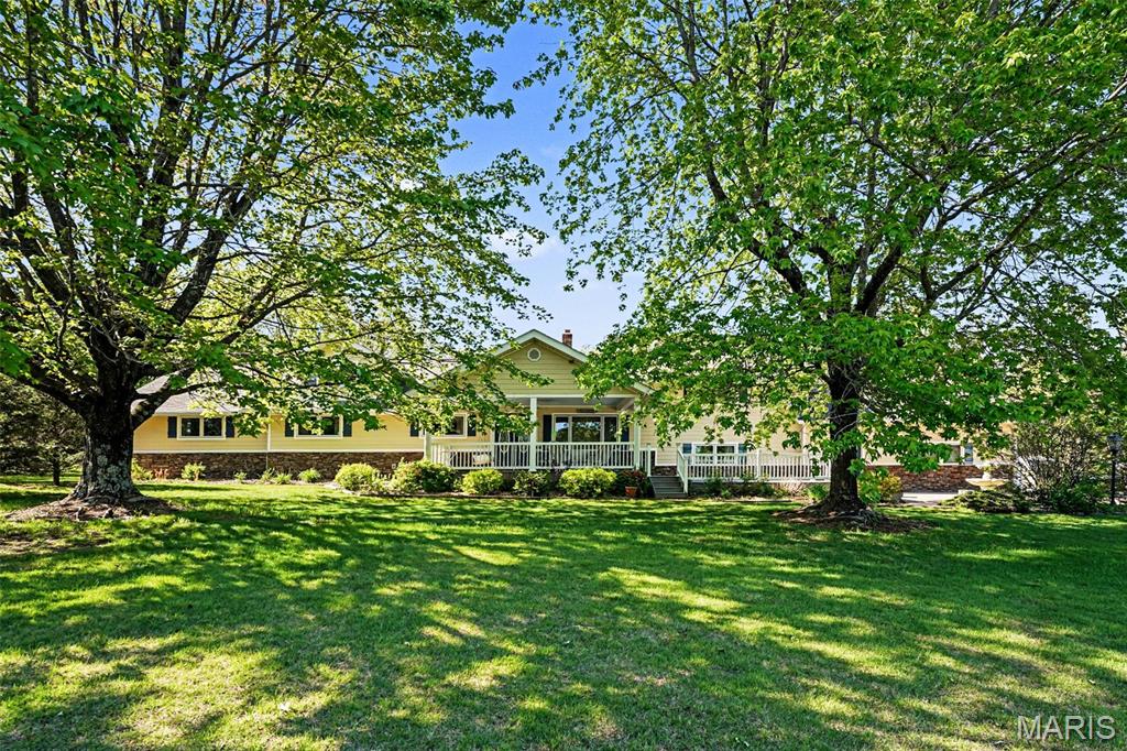 Welcome home to this impeccably maintained sprawling ranch, where generous proportions meet thoughtful upgrades. A massive covered front porch opens into a spectacular foyer, flanked by a sun-drenched living room with bamboo flooring and a sophisticated library featuring custom built-in shelving.  The dining room has wood flooring and gas fireplace.  At the heart of the home, the gourmet kitchen boasts quartz countertops, double ovens, a walk-in pantry, and a breakfast bar. It flows seamlessly into a bright breakfast room and a spacious family room, both offering panoramic views of the private, landscaped backyard. The main-floor primary suite is a true retreat, complete with dual bathrooms, a walk-in closet, and an expansive dressing room. Upstairs find 2 large bedrooms and a bonus room that is currently used as music room plus a full bath. Downstairs is a large bedroom with full bath and expansive utility room with lookout windows.  Zoned heating and cooling, Generac generator, Covered rear patio and trek deck. Lots of great landscaping, lots of hard bamboo flooring,  Oversized 3 car garage with 8' doors. 2-200amp panels, City water and sewer plus a private well, Hardiboard siding with Stone veneer wainscot, zoned heating and cooling. lots of can lights, wood doors plus so much more!
