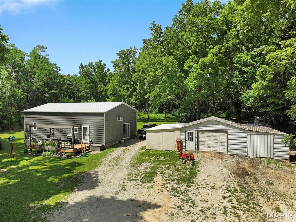 Country Living Meets Modern Comfort on just under 10 Private Acres! Discover the perfect blend of rustic charm and contemporary convenience on these TWO recently constructed all-metal homes nestled on 9.75 expansive acres.  This unique property offers the ideal mix of country serenity and easy access to city amenities! This is a rare find for those seeking a self-sufficient lifestyle with modern touches.  The first home is a 3-bedroom, 2 bath BEAUTY that offers a cozy living space built inside a top of the line heavily insulated metal building. It also features a side master suite for privacy, and two other bedrooms with extra room for guests and family. Cook those home cooked country meals in the updated kitchen that opens to a cute living area and additional bath. The second house is ALSO a spacious metal building where thoughtful design meets everyday functionality! The modern kitchen is a highlight, complete with updated appliances and ample workspace for preparing meals from your own garden or fresh eggs from your backyard of chickens! Laminate flooring throughout provides durable, easy-care living, while the generous primary bedroom offers a peaceful retreat. A versatile second area serves perfectly as a workshop, home office, or additional bedroom—ideal for hobbies, remote work, or future expansion. Stay comfortable year-round while keeping utilities impressively low. A wood-burning stove provides cozy, efficient warmth during winter months, and a powerful wall-unit AC system cools the entire living area during hot summers. Outside, you’ll find a 2-car garage for secure vehicle and equipment storage, a productive garden area ready for your green thumb and abundant wildlife including plenty of deer—making this a hunter’s paradise for bow hunting right on your own land. The property backs up to a private lot, ensuring maximum privacy and room to roam. Whether you’re raising chickens, gardening, exploring the acreage, or simply enjoying the peaceful views, there’s endless space for true country living. Don’t miss your opportunity to own this unique slice of countryside paradise. THIS PROPERTY IS A MUST SEE IN PERSON TO FULLY APPRECIATE!
Schedule your private showing today and start living the lifestyle you deserve!