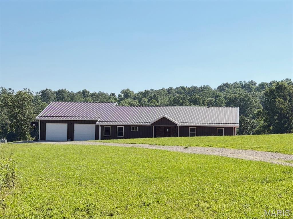 143 Acres With Custom Rustic Farmhouse, A Hunting Paradise! 
Experience the perfect blend of modern comfort, rustic charm, and unmatched privacy with this stunning custom-built 4-bedroom, 2-bath home situated on 143 acres of predominantly wooded land rich with wildlife and outdoor recreation opportunities. Built less than three years ago, this thoughtfully designed home offers quality craftsmanship and country living at its finest. Step inside to an expansive open-concept floor plan featuring heated concrete floors throughout, soaring ceilings with exposed beams, recessed lighting, and abundant natural light. The spacious living, dining, and kitchen areas create the ideal setting for everyday living and entertaining alike. The beautifully designed kitchen showcases hickory cabinetry, stainless steel appliances, a walk-in pantry, and a massive center island complete with a sink and dishwasher. The island was designed with entertaining in mind and can easily accommodate electrical outlets if desired. Home chefs will appreciate the premium range featuring both convection and conventional double ovens with air-fry capability. The spacious primary suite serves as a private retreat with a large walk-in closet and luxurious ensuite bath featuring double vanities, a soaking tub, and a separate walk-in shower. Designed with privacy in mind, the additional three bedrooms and second full bathroom are located on the opposite side of the home, creating an ideal split-bedroom floor plan for families and guests alike. The oversized laundry room offers exceptional functionality with a dedicated office nook, utility sink, water heater, water filtration system, and water softener. Double doors lead to the covered concrete back porch, providing the perfect place to relax and enjoy peaceful views of the surrounding countryside and abundant wildlife. The attached garage is designed for convenience with three overhead doors—two front-facing bays and an additional side-entry door that allows easy access for lawn equipment, ATVs, and UTVs.
Outside, the possibilities are endless. The 143-acre property is primarily wooded with pockets of open valley ground, making it ideal for hunting, recreation, livestock, or creating your dream homestead. The property boasts approximately 988 yards of county road frontage, providing excellent access while maintaining privacy and seclusion. An additional well and electric service are already in place, offering an excellent location for a future residence, guest cabin, hunting lodge, workshop, barn, or other improvements. The home is surrounded by spacious yard areas, including a large front yard, an expansive backyard, and a generous side yard that offers the perfect location for a large garden. Whether you envision growing your own produce, creating outdoor entertaining spaces, or simply enjoying the open green space, this property provides room to make it your own. A well-maintained trail system winds throughout the property, providing easy access to hunting locations and nearly every corner of the acreage. A separate gated entrance offers convenient access to the lower portion of the property. The beautiful valley area creates a natural wildlife viewing corridor where deer, turkey, and other native wildlife frequently emerge from the surrounding woods to feed in the open pastureland. Wildlife is abundant throughout the acreage, making this a true hunter's paradise and an exceptional recreational retreat.