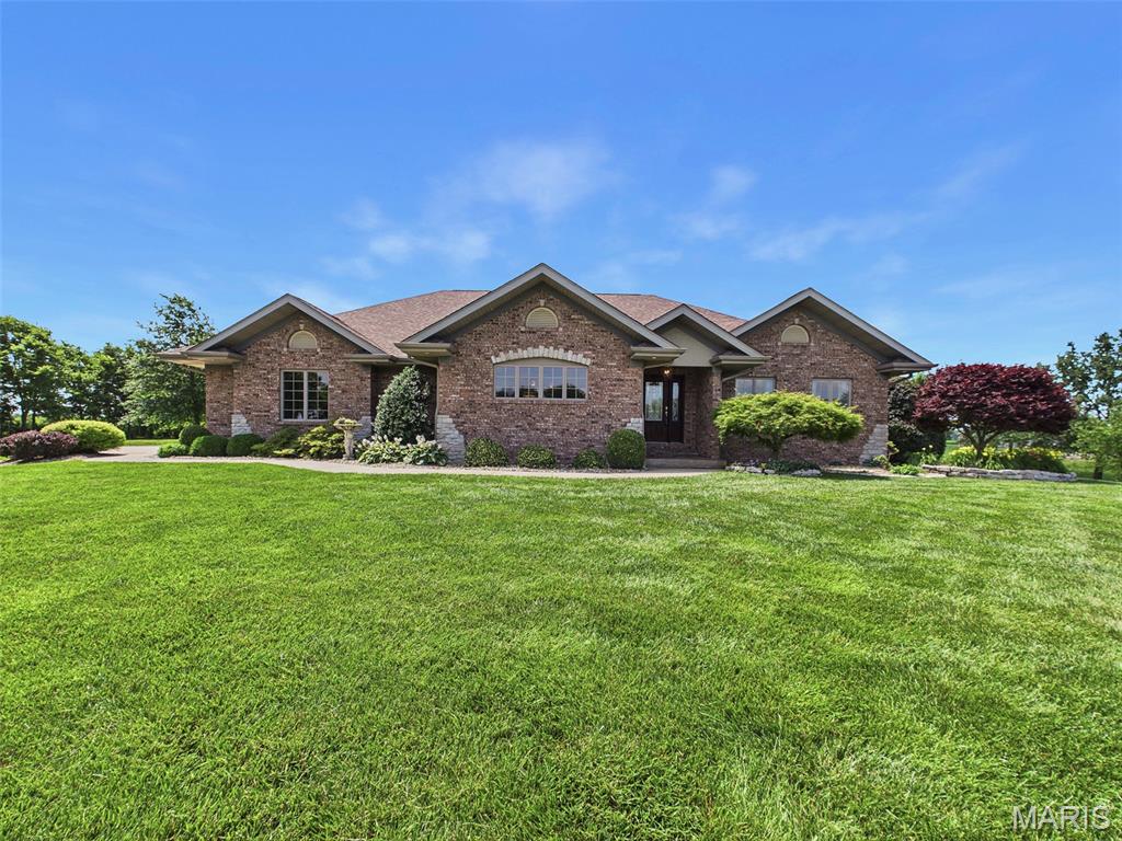 Welcome to this impressive, custom-built one-owner home, thoughtfully designed and impeccably maintained. Situated on 1.52 beautifully landscaped acres, this spacious brick residence offers the perfect balance of privacy and convenience, just minutes from interstate access.

Enjoy breathtaking water views and abundant wildlife, including deer, eagles, and other native species, from the maintenance-free composite deck while sipping your morning coffee or from the patio on warm summer evenings.

The open-concept floor plan is ideal for both everyday living and entertaining. The chef-inspired kitchen features stunning quartz countertops, a center island with an additional sink, and less-than-one-year-old KitchenAid appliances. The spacious primary suite includes dual walk-in closets, providing exceptional storage and comfort.

The walkout lower level was thoughtfully designed with guests in mind, offering privacy and flexibility. It features a large family room with a wet bar and an additional room with a walk-in closet that could serve as a guest room, home office, or potential 3rd bedroom.

Additional highlights include a main-floor laundry room with a built-in ironing board and utility sink, a spacious three-car garage, and a fully paid-off ground-mounted solar panel system. With no lease payments or contracts to assume, you'll enjoy immediate renewable energy benefits and long-term utility savings from day one.

As an added bonus, all televisions currently installed in the home will remain with the property. The dedicated workout room is also being offered fully equipped, including a premium elliptical machine (originally valued at approximately $6,000), a treadmill, and a Nautilus exercise machine.

This one-of-a-kind property combines quality craftsmanship, scenic surroundings, modern amenities, and energy efficiency in a truly exceptional setting.