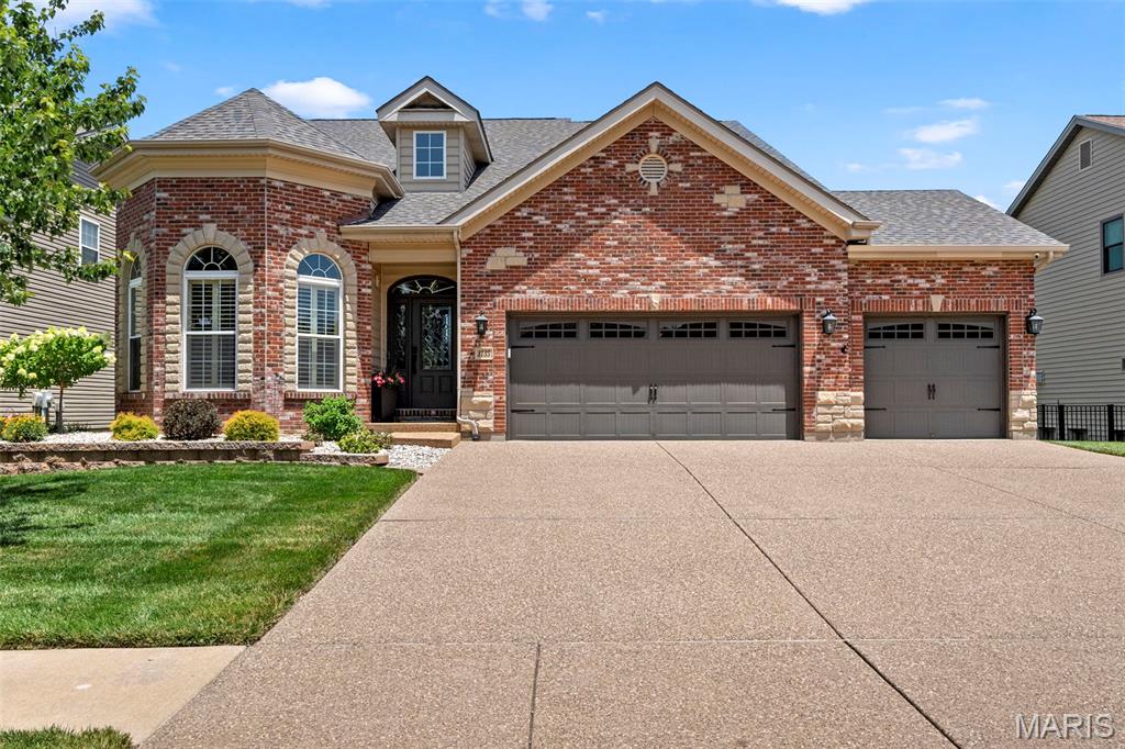 Welcome to luxury and elegance as you step into a home that feels warm and inviting from the moment you arrive. This beautifully and well cared for 1.5-story brick and stone residence offers nearly 3,000 square feet of exquisitely designed living space, complete with a three-car garage, charming curb appeal, and a custom backyard patio perfect for gathering with family and friends.

Inside, the formal dining room showcases one of the homes eye catching features with a tiered coffered ceiling and gleaming hardwood floors. Make your way into the gourmet kitchen with granite countertops, 42 in cabinets, stainless steel appliances and walk in pantry.  Plenty of space allows for an eat in kitchen or to utilize the additional breakfast room. Flow into the spacious great room filled with an abundance of natural light from the dramatic floor-to-ceiling windows also featuring cathedral ceilings and a cozy gas fireplace, creating the perfect gathering space. 

The main-floor oversized primary suite provides a peaceful retreat with 2 walk-in closets, bathroom offers dual sinks, a soaking tub, and separate shower.

Upstairs, you'll find a spacious loft overlooking the great room below—an ideal space for a second family room, home office, or play area. Two additional bedrooms share a Jack-and-Jill bath with dual sinks, offering comfort and privacy for family or guests.

The unfinished lower level is ready for your personal vision, whether you dream of additional living space, a recreation room, home gym, or workshop.  Perfect for increasing your homes value.

Step outside to enjoy the custom patio with stone firepit, perfect for summer barbecues, morning coffee, or relaxing evenings. Backyard is fully fenced to allow kids, grandkids, or pets to run free. With its spacious layout, quality finishes, and welcoming feel, this is a home you'll enjoy for years to come. Located near parks and walking trails, this home offers a wonderful balance of peaceful surroundings and convenient access to outdoor recreation.

Updates include: New roof, HVAC, water heater, carpet, plantation shutters, new interior paint, smart door locks, smart sprinkler system.  Including the washer and dryer in home sale. All you need to do is move in and start making memories.