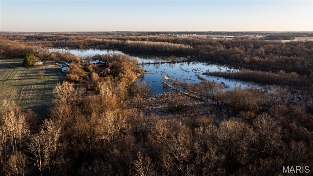 This 263.95+/- acre duck hunter’s dream of a recreational property sits in St. Clair County, Illinois, minutes off Interstate 64. Offering a well-established and turnkey setup for hunting, long stays, and outdoor fun. The property includes approximately 1.25 miles of frontage along Silver Creek and features a managed wetland system designed to control both incoming and outgoing water.

The property is configured with three separate huntable fields, supported by three water control structures that aid water management across the habitat. There are two permanent duck hunting pits and four blinds positioned to provide flexible hunting options depending on water levels, wind direction, and bird movement. Levees separating the fields provide reliable access throughout the hunting areas.

Beyond waterfowl, the property supports great deer and turkey populations with a combination of timber, bedding, established trails, and food sources. Tillable ground and surrounding agricultural land contribute to consistent wildlife use of the area. A 1.7+/- acre fishing pond is stocked and aerated, providing additional recreational use.

Approximately 23+/- acres are in tillable production, generating an estimated annual income between $5,000 and $8,000. A large portion of the property is enrolled in the Wetlands Reserve Program, supporting long-term conservation use while maintaining recreational value.

Sitting on the property is an approximately 1,400 square foot cabin with two bedrooms and two bathrooms. The cabin is supported by electric, gas, water, septic, and a Generac generator. It is suitable for overnight stays and extended use during hunting seasons making it the perfect hunting lodge.

Two barns are located on the property, one of which is fully enclosed. With approximately 5,000 square feet enclosed, this offers plenty of storage for equipment, boats, ATVs, and hunting gear. The other barn has been used as a horse barn with plenty of stables and pens. With some of the pasture area fenced, this could again be suited for horses or other livestock if desired.

The sale includes all existing equipment and machinery, including a JD 250 Series II skid steer with attachments, Polaris Ranger ATV, Farmall 656 Tractor, brush hog, tilers, and additional farm implements.

Access is provided by a long private driveway off Rieder Road that dead ends at the property. The location offers convenient proximity, sitting less than two miles off Interstate 64. The property is situated within the Metro East and is under 30 miles from downtown St. Louis, Missouri. It also sits just minutes from Scott Air Force Base and MidAmerica St. Louis Airport.

This property offers a combination of managed wetland habitat, agricultural income, on-site improvements and endless hunting opportunity. It is nearly impossible to find your dream hunting property in this convenient of a location. Opportunities like this don’t come around often!