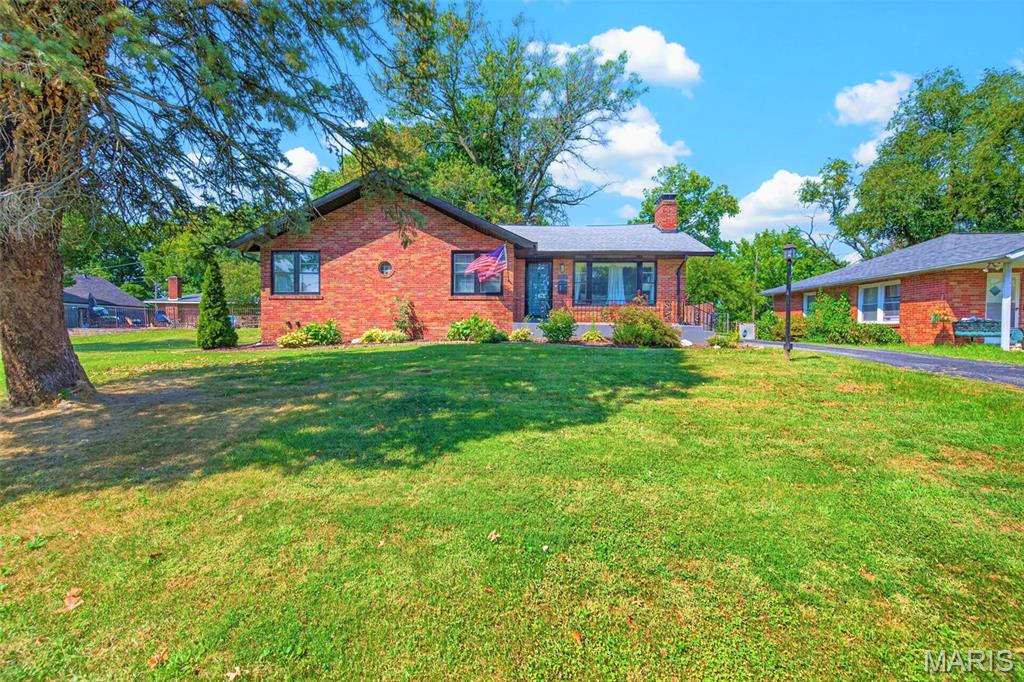 Beautifully updated mid-century (c.1950) multi-colored solid brick ranch home featuring an inviting first impression that blending timeless character with modern updates! Step inside to discover a spacious front living room showcasing gleaming hardwood flooring, an oversized picture window providing an abundance of natural light, and a handsome wood-burning brick fireplace with a wood mantel and marble hearth— creating a warm and comfortable gathering space at the heart of the home.

The adjoining formal dining room features stylish chandelier lighting and flows seamlessly into the beautifully updated kitchen, where walls of bold blue cabinetry, stunning quartz countertops, classic subway tile backsplash, and a full suite of stainless steel appliances create a space that is as functional as it is memorable. Abundant cabinetry and generous counter space provide plenty of room for meal preparation, entertaining, and everyday living.

Three generously sized bedrooms and two full bathrooms complete the main level, including an impressive primary owner’s suite offering a large walk-in closet and private full bathroom. The beautifully updated primary bath features a marble-top double sink vanity, modern fixtures, and a striking glass-walled shower with contemporary tilework. Two additional spacious bedrooms feature hardwood flooring, overhead ceiling fan lighting, and large closets, and share a stylishly updated hall bathroom.

The partially finished lower level provides outstanding flexibility with expansive recreation and entertainment space, a built-in bar area, room for a home gym or hobby space, laundry area, and plenty of additional storage. Whether you’re looking for a game room, home theater, workout area, workshop space, or simply extra room to spread out, the lower level offers an abundance of possibilities.

Step outside and discover a backyard designed for both relaxation and entertaining. The fully fenced yard offers mature shade trees, generous green space, and a large covered patio complete with overhead ceiling fan lighting and a built-in TV—perfect for summer evenings, weekend gatherings, or watching the big game outdoors. The oversized two-car workshop garage is another standout feature, offering a built-in heater and exceptional space for parking, storage, tools, projects, or a dedicated workshop.

Additional highlights include an architectural shingle roof approximately six years old, a long driveway providing plenty of off-street parking, classic solid brick construction, updated interior finishes, and a versatile floor plan that combines everyday comfort with exceptional functionality. Whether you’re searching for mid-century character, modern updates, incredible garage and workshop space, or a large fenced yard built for entertaining, this brick ranch delivers. Call Your Full Time Realtor for Questions or to Schedule Your Showing Today!