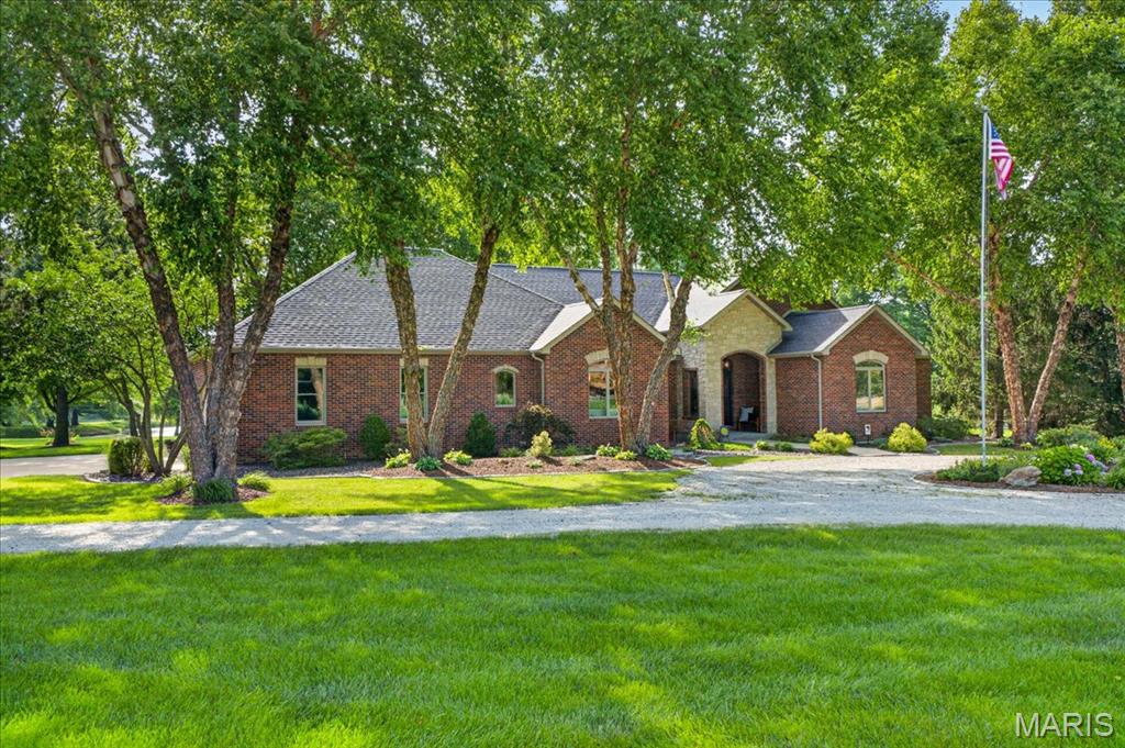 Prepare to be impressed! Nestled on 5.46 picturesque acres overlooking a shared lake and rolling pastures, this one-owner, custom-built executive all-brick and stone atrium ranch offers over 5,700 sq. ft. of thoughtfully designed living space. With 6 bedrooms, 4.5 baths, a finished basement, and a remarkable 60' x 40' barnominium complete with a 800 sq. ft. private apartment, this property truly has it all! Step inside to soaring 12-foot ceilings, stunning Brazilian cherry hardwood floors, and walls of windows that showcase the beautiful surroundings. The great room features a floor-to-ceiling stone fireplace with custom built-ins and flows effortlessly into the beautifully remodeled chef's kitchen featuring quartz countertops, ceramic tile backsplash, gas cooktop with commercial hood, double ovens, Bosch dishwasher, French door refrigerator, walk-in pantry, and spacious breakfast room. A formal dining room with built-in buffet makes entertaining a breeze. The luxurious primary suite offers private access to the backyard, a custom walk-in closet, and a spa-inspired bath with dual vanities, oversized shower, soaking tub, private water closet, and linen storage. Bedrooms two and three share a Jack-and-Jill bath, while bedroom four makes an ideal home office. The finished lower level is designed for fun and relaxation with a spacious family room featuring a second gas fireplace, snack bar, beverage cooler, recreation area, two additional bedrooms, two full baths, home gym, craft room, abundant storage, and a storm shelter that could easily become a wine room or safe room. Outdoor living is exceptional with a covered outdoor kitchen (Gas Grill connected to propane line), Traeger pellet smoker & cooler drawer; pergola-covered dining areas, stamped concrete & porcelain tile patios, composite deck with hot tub, fire pit area, porch swing, raised herb beds, professional landscaping, mature trees and peaceful lake views & abundant wildlife. The impressive barnominium includes loft, storage, workshop, RV accessible door, half bath, and a beautifully finished apartment with full kitchen, living room, dining area, bedroom with walk-in closet, laundry, and covered deck overlooking lake—ideal for multi-generational living, guests, or rental income. Additional highlights include a side-entry oversized 3-car garage, owned solar system powering the home, barn, and apartment (paid in full at closing), new architectural shingled roof (2026), dual HVAC systems (2026), 500-foot well, reverse osmosis system, aerated septic, owned propane tank, security system, and more. Pre-listing home inspection completed, municipal inspections passed, and meticulously maintained inside and out. Located in the highly sought-after Freeburg School District, this extraordinary property is truly one of a kind!!