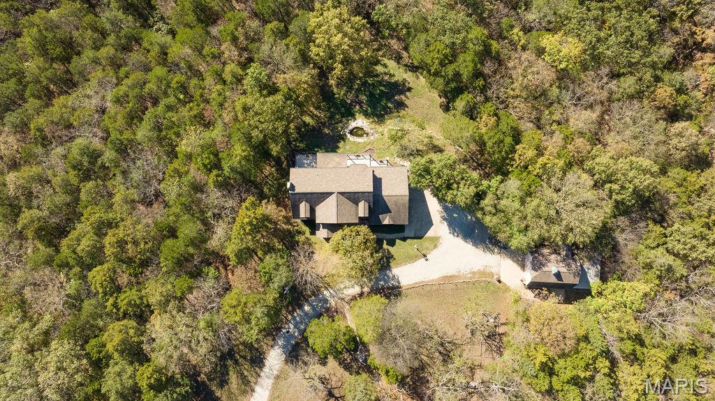 A Very Rare Opportunity — Nearly 14 Acres of Private Living— Large home with new roof and separate out building— 
This extraordinary property offers the perfect blend of privacy, old world charm, elegance and endless potential. From the moment you arrive, the well-lit drive, tranquil fountains, and picturesque landscape set the tone for your true private sanctuary.
Walk into a dramatic two-story foyer and large open staircase, complemented by custom millwork, rich hardwood floors. Light and bright...this home features a large number of Palladian windows and bay windows that frame breathtaking views of the surrounding landscape. The open-concept kitchen and hearth room are designed for both everyday living and entertaining, featuring solid-surface countertops, a breakfast bar, a butler’s pantry, large center island and premium built-in Sub-Zero refrigerator, dishwasher, trash compactor and more. Hearth room features large stone fireplace and both rooms welcome you to step outside to the expansive, beautiful, low-maintenance deck and take in peaceful overlook views—an ideal space for morning coffee or evening gatherings. The primary suite is a true retreat, offering an extra-large bedroom, a spa-like bath with double vanities, a separate shower and soaking tub with a wonderful view, and a generous walk-in closet.

The finished lower level expands the living space with a large family room (also suitable as an additional bedroom), a full bath, large game room, and wet bar, all opening to a private, covered patio—perfect for indoor-outdoor entertaining. Basement also has and additional washer/dryer hook-up. 

Car enthusiasts and hobbyists will appreciate garage parking for five vehicles. Just steps away, a barn-style building with finished second-level space provides exceptional flexibility—ideal for conversion to a barndominium, office, studio, or hobby space... building also has an additional lean-to for outdoor equipment or 6th car...building is not included in the home’s square footage and offers endless possibilities. 

Solid property per seller, was completely built with union labor and also features 2 x 6's in exterior walls plus electric has already been run to the property line for future electric gate installation (controlled by switch at front door). 
Move right in or update to your personal taste—either way, opportunities like this are seldom available. Privacy, views, acreage, and unmatched versatility come together in one remarkable estate.