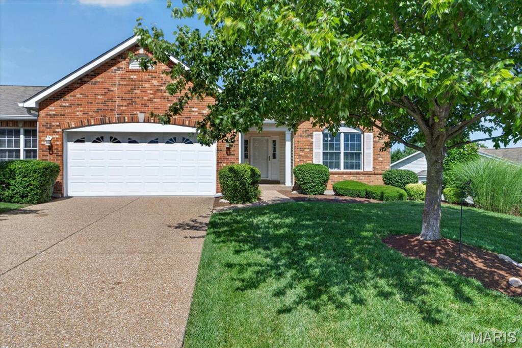 Welcome to this beautifully maintained 3-bedroom, 3-bath villa offering nearly 3,000 square feet of finished living space in the highly sought-after Villages at Dardenne! The attractive brick elevation, manicured landscaping, and covered front porch create an inviting first impression. Inside, you'll find soaring vaulted ceilings, rich hardwood flooring, and an abundance of natural light throughout the open-concept main living area. The spacious great room flows seamlessly into the kitchen and breakfast room, featuring granite countertops, white cabinetry, stainless steel appliances, breakfast bar seating, and ample workspace. Designed with privacy in mind, the desirable divided bedroom floor plan places the spacious primary suite at the rear of the home, tucked away behind the kitchen and main-floor laundry room, while the secondary bedroom and full bath are situated near the front entry—ideal for guests or a home office. The primary suite offers a peaceful retreat with a bay window, generous closet space, and a private en suite bath. The finished walkout lower level is equally impressive with a 9-foot foundation pour and 8-foot finished ceilings, creating an open, airy feel rarely found in lower levels. This expansive space includes a large recreation room, third bedroom, full bath, and plenty of room for entertaining, hobbies, or extended guest stays. Step outside to enjoy the covered deck overlooking mature trees or relax on the covered patio accessible from the walkout lower level. Additional features include main-floor laundry, an oversized 2-car garage, abundant storage, and low-maintenance villa living with fantastic neighborhood amenities including pools, clubhouse, tennis courts, walking trails, and more. Conveniently located near shopping, dining, parks, and major highways, this move-in-ready home truly offers the best of comfort, convenience, and carefree living.