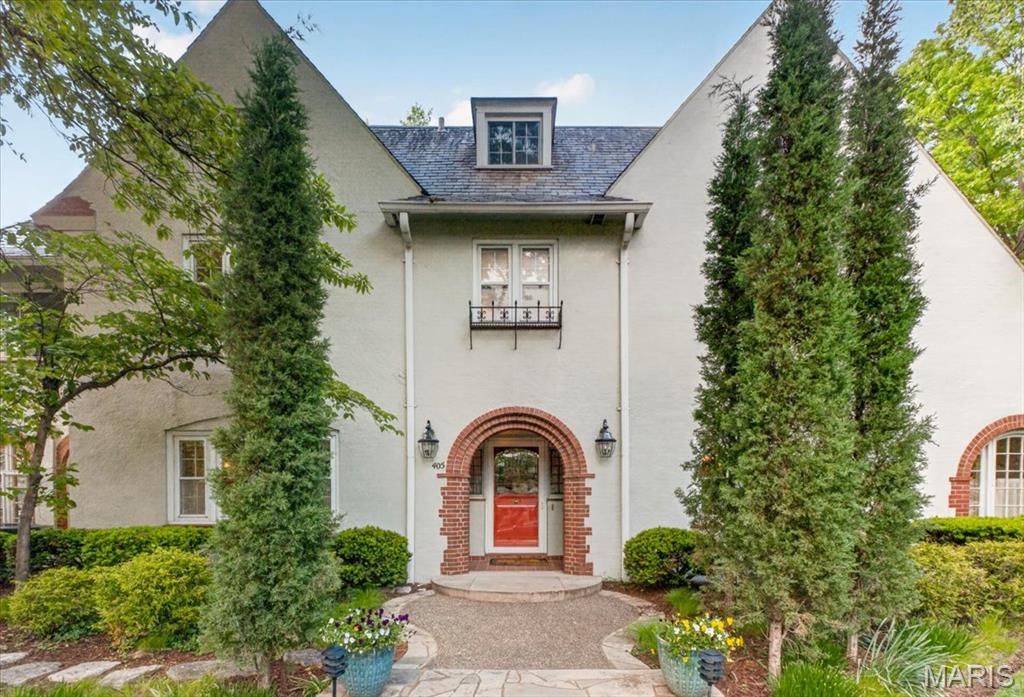 Set on a beautifully landscaped lot in one of Webster Groves’ most sought-after neighborhoods, 405 W. Swon offers a rare blend of timeless architecture, gracious living spaces, and exceptional long-term care. Owned by the same family for more than 40 years, the home has been meticulously maintained and thoughtfully expanded over time. The classic center hall plan creates an elegant introduction, with a spacious living room with fireplace to the left and a large, formal dining room to the right. The kitchen has been updated and features granite countertops, high-end appliances, and a mix of painted and stained cabinetry, with a nearby butler’s pantry and main floor laundry adding everyday functionality. A beautiful family room addition anchors the back of the home, with a second fireplace and windows on three sides overlooking the private backyard. Above, a vaulted home office provides a quiet and inspiring workspace. The second floor includes four bedrooms, highlighted by a primary suite with an adjoining sunroom, along with two full baths. A finished third-floor room adds additional flexibility. Outside, the setting is truly special—mature landscaping, a koi pond, and a large, level fenced yard create a peaceful, park-like environment. A two-car garage is complemented by a circle drive off Rock Hill for additional off-street parking. A home defined by its character, care, and setting, offering a wonderful balance of classic design and comfortable living in a premier Webster Groves location.