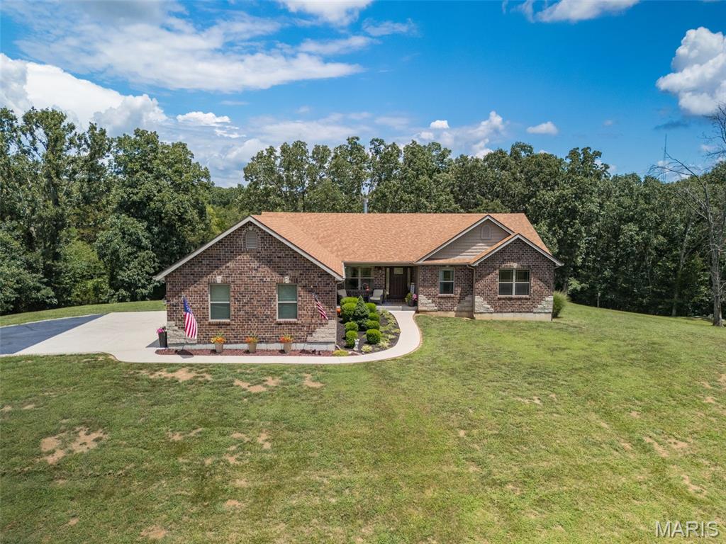 Welcome home to this beautifully appointed 3-bedroom, 2-bath ranch situated on a picturesque 3-acre partially wooded corner lot in a desirable gated community. A stately entrance monument and gated neighborhood entry create a lasting, first impression. Inside, the open floor plan offers comfortable living and entertaining space, featuring bamboo wood flooring, a wood-burning brick fireplace, and abundant natural light throughout.
The well-designed kitchen boasts a center island with breakfast bar seating, ample cabinetry, granite countertop, stainless appliances, extra storage, and a large pantry. Adjacent breakfast room features stylish pendant lighting and walks out to a low-maintenance deck overlooking the private backyard. Convenient main-floor laundry includes built-in cabinetry and a utility sink.
The spacious primary suite offers a vaulted ceiling, charming bay window, and walk-in closet with custom organizers. The luxurious primary bath is enhanced by double-door entry, a walk-in tile shower, separate water closet, and spa-like ambiance. Two additional bedrooms are served by a hall bath featuring a counter-height vanity, tile flooring, and linen closet.
The full-frame walkout basement is ready for your finishing touches with numerous oversized windows for natural light and a full bath rough-in already in place. Completing this exceptional property is a side-entry, oversized 3-car garage. Enjoy the perfect combination of privacy, space, and modern convenience in this stunning country retreat.  When location is everything this home really delivers with only being minutes from schools, golf course and easy highway access.