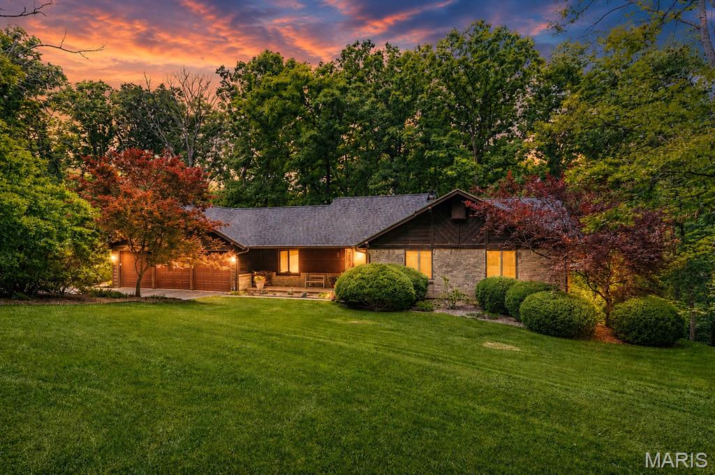 Nestled on a breathtaking and private 3-acre lot in the heart of Defiance, this beautifully updated ranch home offers the perfect blend of tranquility, comfort, and convenience. With 4 bedrooms, 3 full baths, and over 3,500 square feet of thoughtfully designed living space, this home feels like your own secluded retreat among the trees.

From the moment you step into the foyer, you'll be captivated by the dramatic wall of windows across the back of the home, bringing the outdoors in and creating the feeling of living in a treehouse. In the spring, the surrounding woods come alive with stunning blooming dogwood trees, providing a truly picturesque backdrop.

The open floor plan is ideal for both everyday living and entertaining. The vaulted great room features custom built-in bookshelves and an inviting, airy feel. The beautifully updated kitchen is a chef’s dream, showcasing 42-inch custom hickory cabinetry with ambient lighting, granite countertops, a center island, and stainless steel GE Profile appliances, including a wine refrigerator.

Just off the kitchen, the screened-in porch offers the perfect place to enjoy your morning coffee or unwind with a glass of wine while taking in the peaceful views.

The finished lower level expands your living space with a spacious second family room, a fourth bedroom, and a full bath—ideal for guests, a home office, or multigenerational living.

Additional features include a fully drywalled 3-car garage with attic storage, Andersen Windows, gutter guards, exceptionally low monthly utility costs, and newer roof and HVAC systems.

If you've been dreaming of a serene and private setting with the convenience of being just a short drive to major highways, wineries, restaurants, and everyday amenities, this extraordinary Defiance property is one you won't want to miss.