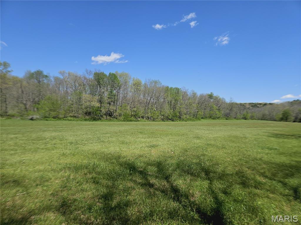 A once-in-a-lifetime opportunity awaits! This breathtaking 370 ACRES M/L is the ultimate Ozark retreat — where luxury living, recreation, ranching, hunting, and income potential all come together in one extraordinary property. Featuring TWO homes, a shop, hay barn, kennel, corrals, nine ponds, live water, three wells, marketable timber, and fenced pastureland, this property is built for the lifestyle you’ve dreamed about.  The beautifully maintained main residence offers 5 bedrooms, 3.5 baths, a full finished walk-out basement, attached 2-car garage, central heat & air with outdoor wood furnace backup, plus tasteful updates including windows, flooring, kitchen counters, sink, and appliances. A charming second home with 2 bedrooms, 1 bath, sunroom, newer roof, and central heat & air creates endless possibilities for guests, multigenerational living, rental income, or an Airbnb retreat.  Outdoorsmen and ranchers alike will appreciate the private rolling landscape of hills, valleys, woods, pasture, and scenic views. Hunt, ride horses or ATVs, run cattle, harvest timber, or simply enjoy unmatched peace and privacy. The timber has been lightly harvested with only approximately 20 acres timbered in the last 15 years, preserving the beauty and value of the land.  Additional amenities include a detached garage/shop with concrete floor, electric, water, and double garage doors on both ends, RV hookups with electric and water, auto-heated waterers, and a fully equipped kennel complete with water heater, sink, and AC units.  Located in rural Dent County less than 5 miles from Baptist Camp access on the Current River and just minutes from Montauk State Park, this remarkable property offers seclusion without sacrifice — approximately 2.5 hours from both St. Louis and Springfield.