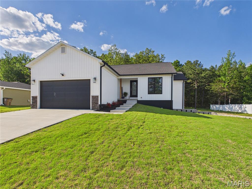 Experience the perfect blend of modern luxury and functional design in this stunning new construction ranch home situated on a serene 0.36 acre lot that adjoins a peaceful wooded area. Built in 2024, this residence offers 1,418 square feet of finished main level living space characterized by an open concept heart of the home. The spacious living room is anchored by a cozy electric fireplace and flows seamlessly into the kitchen and dining areas under elegant vaulted ceilings. The gourmet kitchen comes fully equipped with stainless steel appliances, custom cabinetry, a breakfast bar, and a center island, making it an ideal space for hosting or morning coffee.

The private primary suite serves as a quiet retreat, featuring a generous walk in closet and a luxurious bath with a double vanity and ceramic tile flooring. High quality luxury vinyl plank flooring runs throughout the main living areas, complemented by recessed lighting and solid surface countertops. For those seeking additional space and security, the full walk out basement boasts nine foot pours and a daylight egress window setup. It is already bath stubbed and partially finished to include a dedicated, reinforced safe room that provides ultimate peace of mind for protection of family and valuables.

Outdoor living is equally impressive with a covered front porch and a composite rear deck that overlooks the backyard and forest view. This property includes a two car attached garage supplemented by a concrete driveway and additional gravel parking with enough total space for six vehicles. Located within the Poplar Bluff R-I school district, this home provides a desirable country feel within city limits, complete with public utilities and high speed internet access.