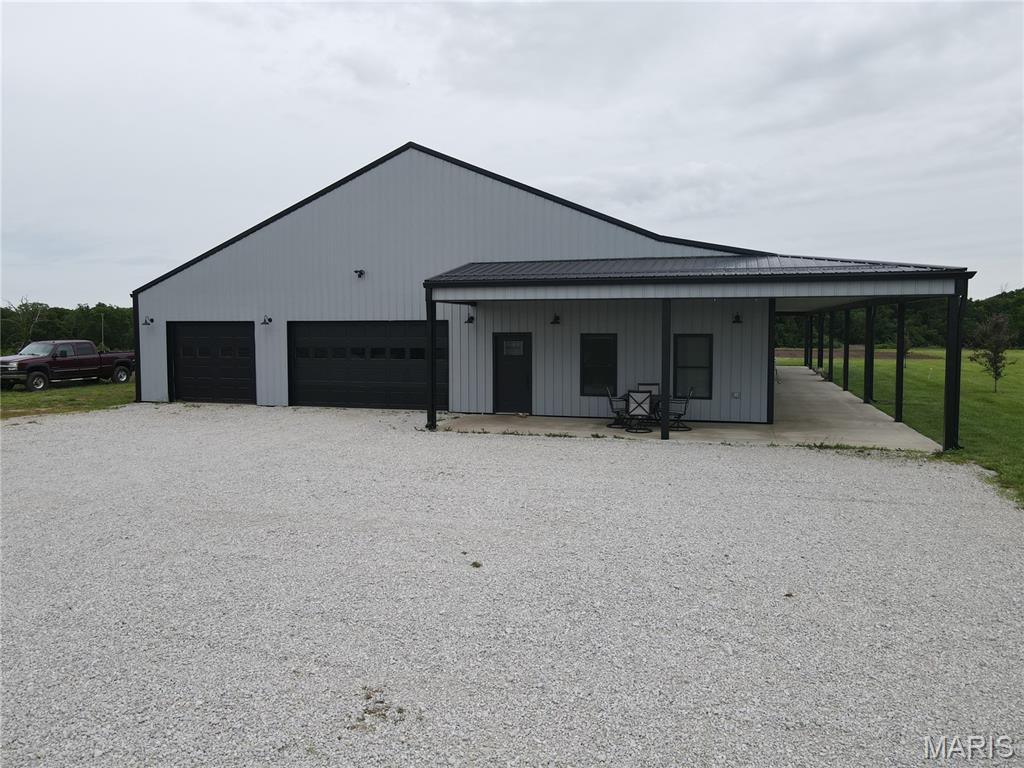 Exceptional 2020-built barndominium on approx. 26.5 acres just 3 miles from Mark Twain Lake! This one-of-a-kind Ralls County property offers the ideal combination of modern living, energy efficiency, shop space, recreation, and peaceful country surroundings. Featuring approx. 2,400 sq ft of finished living space, this thoughtfully designed home includes 4 bedrooms, 3 full bathrooms, and an additional half bath located in the attached garage/shop area.

Inside, you’ll find a warm and inviting open-concept layout with quality finishes throughout. The spacious kitchen features abundant cabinetry, granite countertops, a large island with seating, black stainless steel appliances, and excellent workspace for everyday living or entertaining. The main living area offers a comfortable gathering space with a wood-burning fireplace, hard-surface flooring, and easy access to the covered wraparound patio. The primary suite includes a generous bedroom and oversized walk-in closet, while additional bedrooms and bathrooms provide plenty of flexibility for guests, office space, hobbies, or everyday use.

A major highlight is the approx. 2,400 sq ft attached climate-controlled garage/workshop, complete with finished space, garage door openers, 3 garage spaces, and a half bath. The garage includes 2 overhead doors, one measuring 8x16 and one measuring 8x10, making it ideal for vehicles, lake toys, tools, equipment, workshop use, storage, or hobby needs. Above the living space is approx. 1,200 sq ft of unfinished attic storage, adding even more functionality.

Built for comfort and efficiency, the home features geothermal heating and cooling, a Marathon geothermal/high-efficiency hot water heater, metal roof, vinyl windows, public water, and a gravel drive. Appliances, washer, dryer, and patio furniture convey, with other items negotiable.

The land offers a beautiful mix of open ground, approx. 7 acres of woods, food plots, and excellent outdoor potential. Enjoy room to roam, garden, hunt, entertain, or simply relax and take in the quiet setting. Deer and turkey activity, nearby lake recreation, and wide-open space make this property a standout for outdoor enthusiasts.

Conveniently located near Route J Reservoir, Jellystone Park & The Water Zone, Frank Russell Recreation Area, Clarence Cannon Dam, and Warren G. See Spillway. Only 7 miles from Monroe City and approx. 20 miles from Hannibal, Missouri, home of Mark Twain’s boyhood home. Monroe City R-1 schools. This is a rare opportunity to own a high-quality barndominium with acreage, energy-efficient systems, a climate-controlled shop, and outstanding proximity to Mark Twain Lake.