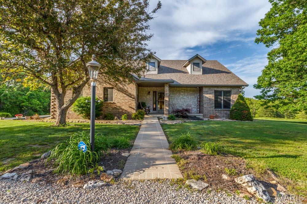 Located in the heart of the Missouri Ozarks and just minutes from Bennett Spring State Park, this incredible 81.35-acre property offers the perfect combination of luxury living, recreational land, and investment potential. With highway frontage, additional access from a side road, and beautiful panoramic views, this one-of-a-kind property provides endless opportunities for homeowners, outdoor enthusiasts, or developers looking for prime acreage in a highly desirable location. As you enter the property, you are welcomed by a private drive surrounded by mature trees, open pasture, and rolling countryside. The stately brick home is perfectly positioned to take advantage of the scenic setting while offering privacy and convenience. Whether you are looking for a full-time residence, vacation retreat, hunting property, or future investment, this estate offers something for everyone. Inside the home, you will find spacious living areas filled with natural light and timeless charm. The main living room features a beautiful wood-planked ceiling and an open layout that creates a warm and inviting atmosphere. The kitchen offers abundant oak cabinetry, generous counter space, and a large center island that is perfect for cooking, entertaining, or gathering with family and friends. The home includes comfortable bedrooms, including a relaxing primary suite, along with additional living space in the lower level that could be used for recreation, guests, or extra entertaining space. Large windows throughout the home provide peaceful views of the surrounding acreage and allow you to fully enjoy the beauty of the Ozarks from nearly every room.
Outdoor living is equally impressive with a large deck overlooking the property and offering the perfect place to enjoy morning coffee or evening sunsets. A spacious patio below provides additional room for entertaining, cookouts, and relaxing while surrounded by nature. The 81.35 acres offer an excellent mix of wooded land, open pasture, and gently rolling terrain. The property is ideal for hunting, hiking, horseback riding, ATV trails, hobby farming, or livestock. Abundant wildlife and scenic views create a true outdoor paradise while still being conveniently located near town and just minutes from Bennett Spring State Park, known for its trout fishing, camping, and year-round recreation. For investors and developers, the property offers exceptional potential with extensive highway frontage and additional road access. The layout and location make it attractive for future residential development, vacation cabins, luxury home sites, or even a private gated community. With the continued growth and popularity of the Bennett Spring area, opportunities like this are becoming increasingly rare. This property offers the perfect balance of peaceful country living, recreational opportunity, and future investment potential. Whether you are searching for a private family estate, recreational retreat, or development opportunity, this remarkable 81.35-acre property delivers endless possibilities in one of the most desirable areas of the Missouri Ozarks.