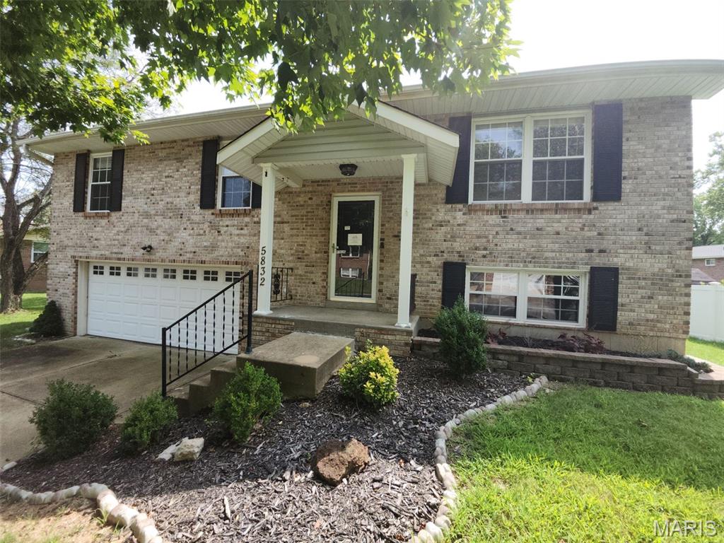 This split-foyer residence at 5832 Blackberry Drive offers approximately 1,405 square feet of living area with 3 bedrooms and 2 full bathrooms. The main level features an open-concept living and dining area. The kitchen includes appliances, cabinetry, and a central island with storage. Downstairs, a partially finished lower level provides a secondary recreation area, laundry facilities, and extra storage. Situated on a flat 0.23-acre lot, the exterior includes a fully fenced backyard, a deck, a concrete patio, a storage shed, and an oversized two-car garage.