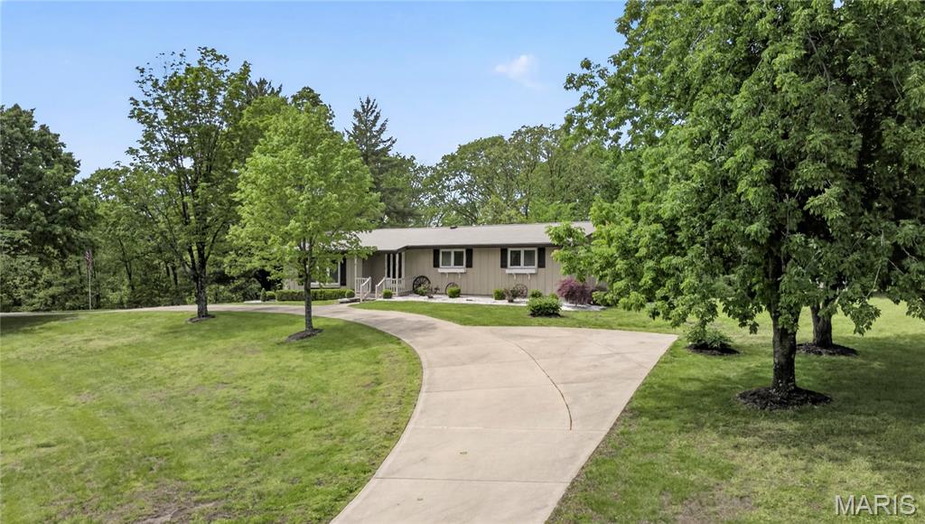 Beautifully situated on one of the highest points on Terry Road, this impeccably maintained 3 bedroom, 2 full and 1 half-bath home sits of 4.97 acres that include spacious front and back lawns and adjoining wooded acreage.  The front entry leads to a spacious living room with large windows offering exceptional views over the property. An adjoining dining room creates a large open space. The eat-in kitchen features lots of storage, custom cabinetry, hard surface countertops and tile backsplash. The finished lower-level family room with fireplace, full bath and laundry room offers plenty of space for entertaining family and friends.  This level also includes loads of storage space and a 2-car tuck-under garage. A large deck with custom-made, retractable electric awnings runs along the rear of the home providing additional outdoor entertaining space. An attractive storage shed offers plenty of room for lawn mowers and garden equipment. This special property has been lovingly cared for and is in a superb location.