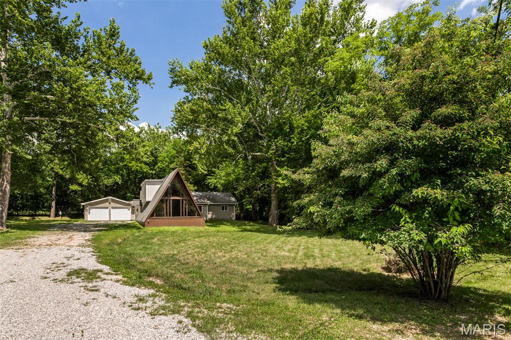 Coming Soon. Showings begin Wednesday 7/22. 
Looking for a custom, unique, newer home with recent updates on a gorgeous piece of ground? Look right here!

This charming 1.5-story part A-frame and part ranch perfectly blends modern design with character and warmth. Situated on a beautiful, level, tree-lined half-acre lot, you will enjoy a private, serene setting with all major amenities located nearby.

Property Highlights:
Interior Features: Step inside to find a ceramic-tiled kitchen, updated baths, and updated main-floor laundry. The spacious eat-in kitchen flows effortlessly into an adjoining formal dining room.

Unique Layout: The stunning A-frame serves as the main family room, with dramatic vaulted ceilings and beautiful wood beams. A versatile entry foyer or office nook separates the family room from the dining area, while two spacious main-floor bedrooms are located down a quiet, separate hallway.

Upper Level Loft: Upstairs features a private 3rd bedroom equipped with dual closets and a fantastic lookout loft area that overlooks the family room below.

Storage & Parking: Park with ease in the oversized, attached 2-car garage, which includes a custom-built storage room.

Outdoor Living & Systems: Enjoy the beautiful grounds from your decorative patio. The home comes loaded with premium features including bright skylights, newer zoned HVAC systems with Wi-Fi capabilities for maximum efficiency. Water service upgraded to an 1 1/2" service.  Water hydrant added for an RV hookup.  A second 200 AMP electrical panel was added to use at a remote shed or RV. Waste connection added for an RV.  Water heater replaced last year (10 months old) and new septic system installed.
