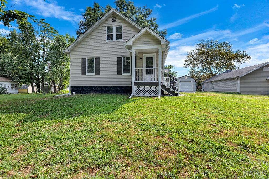 There is a distinct rhythm to life in a classic 1940s bungalow, where mornings naturally begin with a quiet cup of coffee on a freshly painted front porch. Set on a generous third-of-an-acre lot in Bethalto, this home balances its historic character with thoughtful, practical updates that make daily living effortless. It is a space designed for those who appreciate the charm of an earlier era but want the clean, refreshed feel of a well-cared-for home.

Inside, the layout feels bright and intentional. Every room has been given a fresh breath of life with crisp paint across the walls, ceilings, and trim, complemented by brand-new hardware on every door. The bedrooms offer comfortable retreats with freshly steam-cleaned carpets underfoot, providing a soft landing at the end of the day. With three bedrooms and two full bathrooms, the footprint is highly adaptable—ideal for a first-time buyer setting up a guest room and a home office, or a small family needing room to grow.

The living space extends outdoors to the back porch, where a newly replaced window frames views of the expansive, level backyard. Shaded by mature, recently trimmed trees, this outdoor area offers plenty of room for summer evening gatherings, gardening, or simply enjoying the quiet surroundings. Downstairs, the full unfinished basement provides a massive blank canvas for storage or a workshop, while a detached garage keeps vehicles and tools out of the elements.
