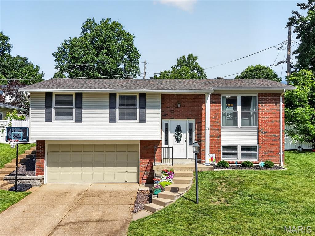 Impressive, 3 bedroom, 2 bath home in the highly desirable Rockwood school district.  There is excellent curb appeal with brick, vinyl siding, leaded glass front door, architectural shingles, enclosed fascia/soffits, 2 car garage, tasteful landscape and steps that go from the driveway to the back yard on the side of the house.  Features include an open floor plan, laminate flooring throughout the main living areas, white shaker-style cabinets in the Kitchen with hardware, stainless steel appliances, smooth top range, microwave, dishwasher, refrigerator, large butlers pantry/beverage center, spacious Dining area open to the Living Room, white 6 panel doors, raised height bath vanities, double tilt windows, ceiling fans, exposed tread steps, generous sized secondary bedrooms and more.  The Primary Suite is amazing (17’4 x 13’5) with a farmhouse style, painted brick, woodburning fireplace and hearth, walk in closet with custom organizers, beamed ceiling and glass doors that open to a covered patio. The lower level has a Family Room, closet, full bath and storage.  The garage is oversized (22’5D) and has an opener.  Updates include HVAC in 2022, new roof and gutters in 2025 and new flooring in 2022.  There is a covered patio that is accessible from the kitchen and the Primary Bedroom and a fenced back yard for outdoor enjoyment.  Excellent location near shopping, restaurants, services and recreation.  There is easy access to Highways 141, I-44 and 270.  Excellent home, fantastic location, top rated schools, so much to love!