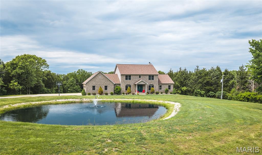 Located in the highly desirable Cedar Breeze Subdivision in Franklin County, Missouri, this exceptional custom two-story home offers a rare opportunity to own private acreage with upscale living space just minutes from Sullivan. Situated at the end of Cedar Breeze Drive on just over five acres, this property combines privacy, functionality, and scenic surroundings in a setting that is increasingly difficult to find this close to town.

Backing to larger neighboring tracts, the property offers a secluded atmosphere with mature timber creating a peaceful natural backdrop. The end-of-road location enhances privacy while still providing convenient access to schools, amenities, and major travel routes. Whether you're seeking a full-time residence or spacious country home near town, this property delivers an ideal blend of acreage and convenience.
The home features more than 3,700 square feet of above-grade living space with a thoughtful layout designed for both everyday living and entertaining. Inside are four spacious bedrooms and five and a half bathrooms, offering flexibility for family, guests, or multi-functional living arrangements. Large living areas create room for gathering, relaxing, or home office space. A standout feature is the mostly finished walkout basement, adding valuable versatility for recreation, fitness, guest quarters, hobbies, workspace, or additional entertaining. The walkout design expands both accessibility and functionality.

Outside, the oversized rear deck overlooks the expansive backyard and surrounding timber, creating an ideal setting for outdoor dining, entertaining, or simply enjoying peaceful views. The transition from maintained yard to wooded cover enhances privacy and visual appeal.
Just over five acres provides usable space for recreation, gardening, hobby projects, or future improvements such as a detached shop or additional amenities, subject to local requirements. Unlike many subdivision properties, this home offers a spacious rural feel while remaining in a developed residential setting.

A small pond adds charm and visual interest, while an older homestead structure contributes historic character and individuality rarely found in comparable properties. Wildlife and nature lovers will appreciate the wooded backdrop, open space, and frequent opportunities to observe deer, songbirds, and other native Missouri wildlife.

Located less than two miles from Sullivan city limits and within the Sullivan School District, the home offers quick access to shopping, dining, healthcare, and Interstate 44. Buyers seeking privacy, acreage, and finished living space near town will appreciate how uncommon this combination truly is.

With over 3,700 square feet, four bedrooms, five and a half bathrooms, a mostly finished walkout basement, pond, mature timber, historic character, and over five acres in Cedar Breeze Subdivision, this Franklin County property stands out as a truly unique offering. If you’ve been searching for a luxury country home near Sullivan, Missouri with acreage, privacy, scenic features, and spacious custom construction, this exceptional property deserves a closer look. Contact the listing agent today to schedule a private tour.
