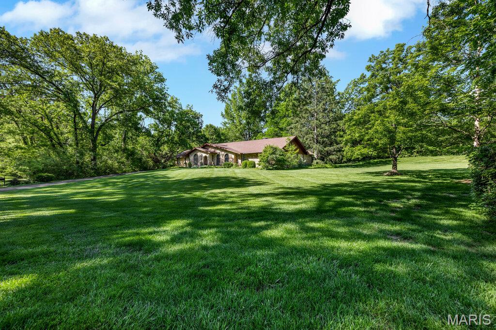 Prestigious location, incredible lot, and meticulously maintained ranch on 2-acres. An exceptional opportunity to personalize or reimagine this sprawling ranch on a beautiful, level, park-like lot complete with 4 car garage. Located in a highly sought after neighborhood, the home boasts hardwood floors, spacious living spaces, expansive primary suite, finished lower level, and extensive storage with room for all your hobbies. Large kitchen, family room and primary suite all open to large patio overlooking idyllic yard. With unmatched flexibility for expansion, this cared for home offers peaceful privacy on outstanding acreage, while being just minutes from shopping, dining, highways and everyday conveniences.