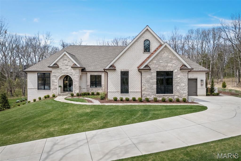 Experience unparalleled luxury in this custom estate, masterfully situated on five+ pristine wooded acres. A grand arched iron entry door welcomes you into an airy interior defined by 10’ ceilings and stunning engineered white oak flooring. Natural light pours through Pella’s top-of-the-line fiberglass windows, featuring integrated hardwired electronic shades for effortless privacy. At the heart of the home, the sun-lit Great Room—anchored by a floor-to-ceiling stone fireplace and custom built-ins—flows seamlessly into a chef’s kitchen. This culinary masterpiece features professional-grade appliances, quartz countertops and a premium butler’s pantry. The primary suite serves as a private sanctuary, boasting coffered ceilings with wood beams and a spa-inspired bath complete with a steam shower, free-standing tub, and sleek floating vanities. Two additional bedroom suites provide the same elevated luxury, each featuring private en-suite bathrooms and walk-in closets.  Entertaining is effortless on the covered patio, featuring an outdoor fireplace and grill area that overlooks a spectacular in-ground saltwater pool. The pool area is a true resort, finished with a tanning deck, heater, and electronic cover. For ultimate convenience, a dedicated pool suite provides a changing area, laundry, and bathroom with direct outdoor access. The finished lower level expands your living space with a 9' pour, a recreation hub with a custom bar, and an additional bedroom and bathroom. From the copper gutters to the bluestone pavers, every detail of this estate is an upgrade!