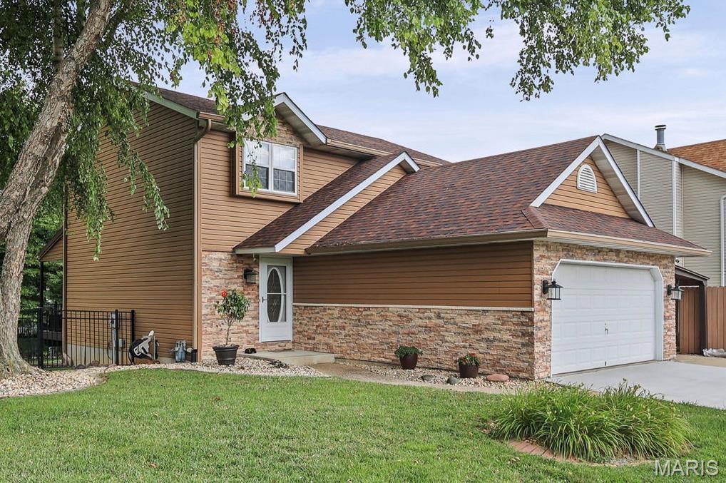 Welcome to this updated two-story home in Rolling Meadows Subdivision! The main level makes an immediate impression with beautiful hardwood floors spanning the living and dining rooms. The oversized living room anchors the space with a classic wood-burning fireplace, while the eat-in kitchen is designed for real everyday living—packed with cabinet and counter space, stainless steel appliances, and fresh, new tile flooring. A convenient half bath completes the main floor. Upstairs, the layout delivers exactly what you need. The primary suite serves as a true retreat, featuring an updated full bathroom and dual closets that maximize storage. Two additional generously sized bedrooms and a second updated full bath provide the perfect flexibility for a growing household. Head down to the walk-out lower level to find a fully finished family room complete with a dedicated bar, a half bath, and a large storage room ready for whatever fits your life. Outside, the exterior spaces are a genuine standout. You are going to absolutely love the fully fenced, park-like backyard, which comes ready for entertaining with a multi-level Trex deck, beautifully landscaped retaining walls, and a built-in concrete fire pit. Complete with a two-car garage and an additional carport for extra parking flexibility, this home is ready for its next chapter. Call your favorite Realtor today to schedule a private tour!