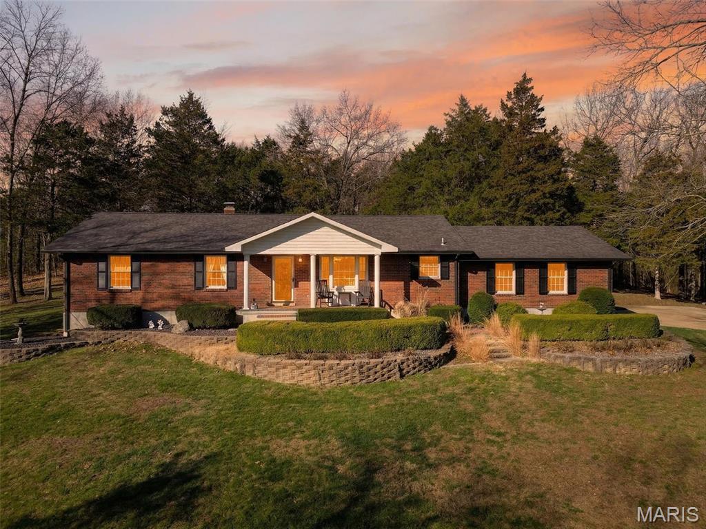 Rarely does a property combine privacy, flexibility, and function this well. Set on 3+ private wooded acres, this beautifully maintained home offers over 2,000 square feet of living space, an easy conversion from 2 bedrooms back to 3, a finished lower level, an oversized attached 2-car garage, and a large detached outbuilding with concrete floors for hobbies, storage, vehicles, equipment, and more.

This rare offering blends refined comfort, flexible living space, and exceptional utility in one meticulously kept property. Tucked into a peaceful setting just minutes from Hwy 55, Mastodon State Historic Site, shopping, dining, and an easy commute to St. Louis, it delivers the privacy buyers want without giving up convenience.

Inside, you will find a spacious open layout with hardwood and tile flooring and a design that feels both warm and expansive. One of the standout features is the flexible bedroom configuration—currently a generous 2-bedroom layout, with an easy conversion back to a 3-bedroom for buyers needing additional sleeping space, guest accommodations, or a dedicated office.

The main living areas are bright, open, and inviting, centered around a large kitchen with abundant cabinetry, extensive counter space, a center island, and seamless flow into the dining and living spaces. A gas fireplace adds warmth and character, while the open-concept design creates an ideal setting for both everyday living and entertaining.

The finished lower level expands the lifestyle appeal with a large recreation area, built-ins, wet bar, and ample room for gathering, gaming, hobbies, fitness, or work-from-home flexibility. Every space reflects long-term ownership, meticulous care, and true pride of ownership.

Outside, the amenities continue. The oversized attached 2-car garage is complemented by a substantial detached outbuilding with concrete floors, offering outstanding versatility for hobbyists, collectors, workshop needs, equipment storage, recreational vehicles, outdoor gear, or additional vehicle space. The concrete driveway, mature trees, and private wooded backdrop complete the setting and give the property a sense of retreat rarely found this close to everyday conveniences.

Located in the Seckman School District, this is the kind of property that rarely comes available: thoughtfully designed, exceptionally maintained, and positioned for buyers seeking privacy, quality, flexible square footage, and room for hobbies, storage, and entertaining.