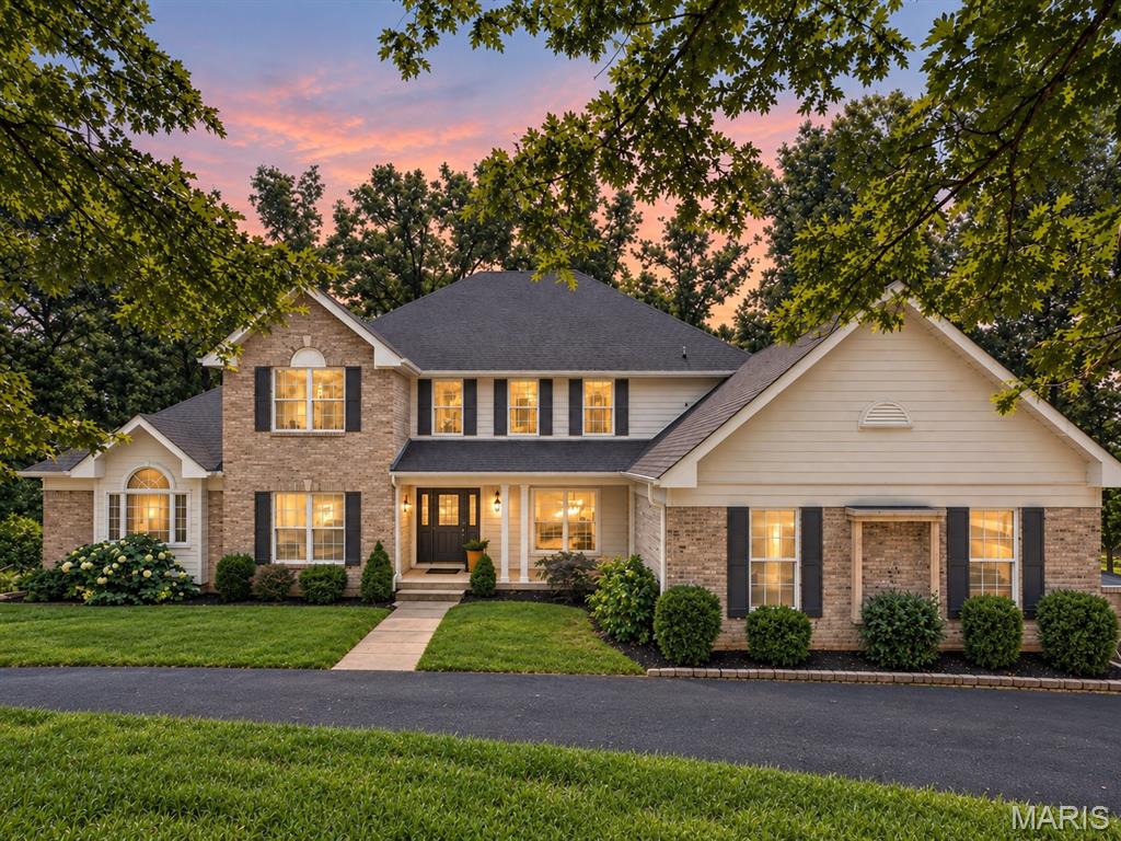 Tucked away on 3 beautiful acres with peaceful lake views, this 5-bedroom, 4.5-bath home offers nearly 3,900 square feet above grade and the perfect blend of character, comfort, and room to spread out. Step inside the impressive two-story foyer, where hardwood floors carry you into a home filled with thoughtful details and inviting spaces. The two-story great room immediately draws you in with soaring vaulted ceilings, a fireplace, and a stunning wall of windows framing the wooded surroundings and lake beyond. At the heart of the home, the spacious kitchen is designed for both everyday living and entertaining with custom cabinetry, stainless steel appliances, a gas cooktop, wall oven, center island, and walk-in pantry. Just beyond, the breakfast/hearth room creates another warm gathering space with built-in shelving, a butler’s pantry, and an additional fireplace. The main-floor primary suite feels like a true retreat, offering generous space, a walk-in closet, private deck access, and an en suite bath with dual vanities, separate shower, and soaking tub. A second main-floor bedroom provides flexibility for guests or an office, while upstairs you’ll find three additional bedrooms, including a Jack-and-Jill arrangement and another private en suite. The partially finished walk-out lower level extends the living space even further with a large family room, recreation area, full bathroom, and plenty of room to make the space your own. Outside is where this property truly shines; multiple deck spaces overlook the wooded acreage, while the expansive grounds lead toward the lake, creating a setting that feels private, peaceful, and worlds away while still offering all the comforts of home. An oversized 3-car garage, main-floor laundry, and Rockwood Schools complete this one-of-a-kind property.