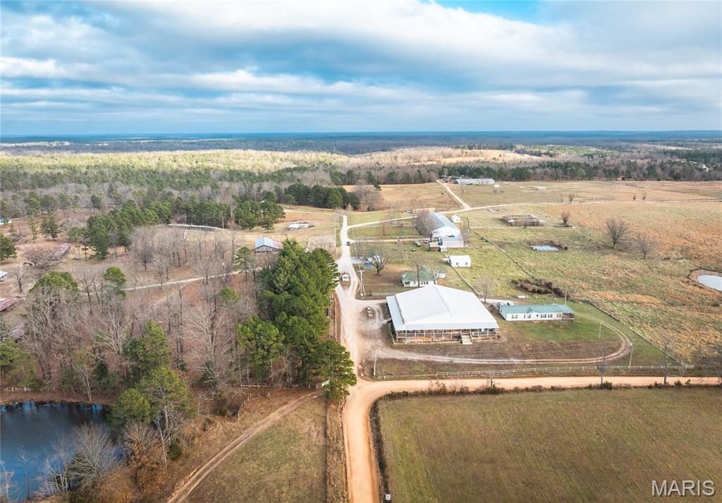 Opportunity awaits with this 57.7 m/l acre equine resort property offering infrastructure and scale that are hard to find. Designed to accommodate large events, extended stays, and recreational gatherings, this property features over 300 campsites, with the vast majority equipped with electric and water hookups, making it ideal for trail ride events, rallies, festivals, or seasonal tourism operations. On the property is a 10,000± square foot building that was once used as a general store housing an office area, restaurant space, and retail showroom—perfect for on-site management, concessions, or event services. Also, a 12,000± square foot dining hall  with a kitchen, walk-in coolers, and a 12-foot-wide covered porch wrapping three sides of the building, offering ample space for large gatherings, banquets, or entertainment. Lodging options include a 21-unit motel (partially remodeled & 2 of the units were converted into an apartment ), 2-story bunkhouse, and a 3-bedroom, 1½-bath mobile home suitable for owner or manager living quarters. Additional infrastructure includes a well house with 2,000-gallon tanks, shop building, multiple sheds, and a large former chicken house adaptable for storage or alternative uses. The equine facilities are extensive, featuring  pipe corrals and pens, providing a solid foundation for a premier horse-focused operation. Recreational amenities round out the property with a swimming pool and pavilion, enhancing guest experience and event potential. With its size, layout, and existing improvements, this property offers several possibilities—from revitalizing a full-scale equine resort to creating a multi-use campground, event venue, or recreational retreat. Conveniently located approximately 2 1/2  hours from St. Louis, 1 1/2 hours from the Current River, less than 1 hour to Mark Twain National Forest and 1 1/2 hours from Springfield, this unique property is ready for new ownership and a fresh vision to bring it back to life