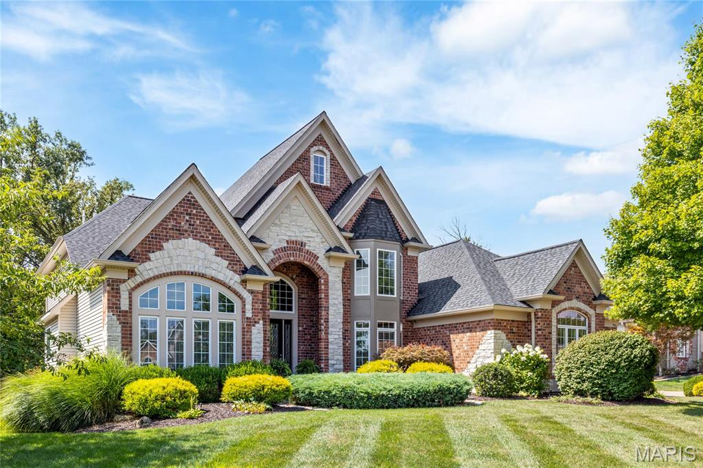 This spectacular 1.5-story brick and stone estate, built by renowned Arbor Homes, is situated on a beautifully landscaped 0.5-acre lot and offers timeless elegance with modern comfort. A grand 2-story foyer with a floating staircase welcomes you into an open, light-filled floor plan featuring rich hardwood floors throughout the main level. The private study boasts 12’ ceilings and custom built-ins, while the formal dining room is framed by elegant arched entryways. The great room features soaring 2-story windows and a stunning marble fireplace. Recenly updated kitchen includes 42” custom buff cabinetry, premium stainless appliances, walk-in pantry, and opens to a vaulted hearth room with floor-to-ceiling brick fireplace. A bay-windowed breakfast room and atrium door lead to the covered deck—perfect for outdoor dining. The luxurious coffered-ceiling primary suite includes a spa-like bath and a custom walk-in closet. Front and rear staircases lead to three upper-level bedrooms and two full baths. The finished walk-out lower level features a large rec room, game area with wet bar, dining space, and full bath. Enjoy resort-style living with a gunite pool, spacious patio, and oversized 3-car garage.