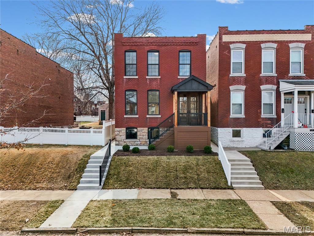 An extraordinary offering on The Hill — a fully reimagined, down-to-the-studs renovation presenting two independent residences on a single city lot. A configuration of this caliber is exceptionally rare in one of St. Louis’ most storied and culturally rich neighborhoods. The primary residence showcases a timeless all-brick exterior, new windows, a newly constructed front porch, and a striking custom wood-stained entry door. Inside, reclaimed original hardwood floors have been thoughtfully preserved, blending historic character with refined modern finishes. Soaring ceilings enhance the open feel, while the designer kitchen serves as the heart of the home — appointed with 42” custom cabinetry with crown molding and hardware, quartz countertops, a gas range, and generous space for elevated entertaining. Upstairs, you’ll find three well-proportioned bedrooms, two full baths with curated finishes, and the convenience of second-floor laundry, seamlessly combining convenience with functionality. The professionally landscaped grounds create a cohesive and private setting between both homes. The rear residence offers two bedrooms, one full bath, an updated kitchen, and dedicated laundry — ideal for sophisticated multi-generational living, private guest accommodations, or a strategic investment opportunity. Positioned just moments from The Hill’s renowned Italian dining and neighborhood landmarks, this property delivers architectural character, modern refinement, and unmatched versatility — all in one of St. Louis’ most desirable enclaves. A rare opportunity to own something truly distinctive.