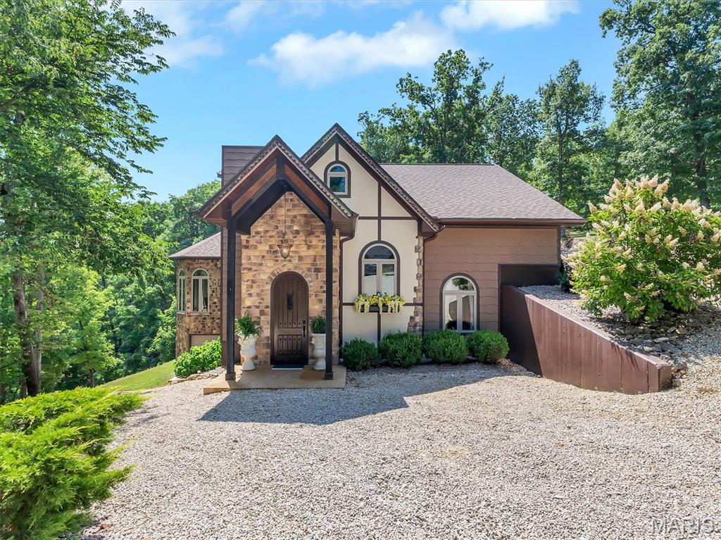 Welcome to an extraordinary lakefront retreat nestled within the private, gated community of Anthonies Mill. Situated on approximately 2 acres, this stunning 1.5-story home offers the perfect blend of luxury, craftsmanship, and lakefront living with exceptional attention to detail throughout.

As you enter through the home’s beautiful arched front doors, you are welcomed by a grand staircase to the right and a built-in wine cellar, setting the tone for the quality and character found throughout the home. Every detail has been thoughtfully designed, from the custom woodwork to the stunning wood-paneled ceilings featured throughout the home.

The heart of this home is the breathtaking custom kitchen, designed for both everyday living and effortless entertaining. Featuring custom cabinetry, abundant counter space, a large pantry, newer stainless steel appliances, trash compactor, warming drawer, wine cooler, and a spacious breakfast bar, this kitchen seamlessly opens to the family room, creating the perfect gathering space for family and friends. The dining area leads to a beautiful separate living room featuring a second gas fireplace, elegant chandelier, and massive arched windows that fill the home with natural light.

The inviting family room offers vaulted ceilings and a cozy gas fireplace, creating a warm and welcoming atmosphere. The impressive primary suite is a true private retreat featuring dramatic vaulted ceilings, a beautiful chandelier, private French doors leading to the back deck, and a spacious walk-in closet. The spa-inspired ensuite bathroom offers dual vanities and a large glass walk-in steam shower, providing the perfect place to relax and unwind.

The main level includes two additional bedrooms, a full bathroom, and convenient main-floor laundry. Upstairs provides additional flexibility with a full bathroom, dedicated office space, and a spacious loft featuring a Murphy bed—perfect for guests, additional sleeping accommodations, a media space, or entertaining.

This home is being sold furnished (excluding select wall decor) allowing you to immediately enjoy your lakefront lifestyle. Step outside to an exceptional outdoor living space designed for entertaining and relaxation. The expansive deck and patio offer the perfect setting for gatherings, featuring a lounge area, hot tub, and gas grill overlooking the tranquil lake surroundings. Follow the path to a private fire pit area, ideal for enjoying peaceful evenings under the stars. Continue down to your private 20’ x 27’ boat dock complete with slip and lift, providing effortless access to all your lake adventures. A charming lakeside guest retreat awaits, featuring heating and cooling, bunk beds, refrigerator, counter space, and additional storage—perfect for hosting family and friends or creating the ultimate lakeside escape.

Additional highlights include a detached two-car garage with heating and cooling, a tuck-under one-car garage, interior safe, a buried propane tank and a gas-powered Ranger utility vehicle included with the home for convenient transportation from the house to the lake. Also, for added peace of mind the roof was replaced in 2025. 

Anthonies Mill offers incredible amenities including lake access, beach, swimming pool, picnic areas, beach volleyball, tennis, pickleball, basketball courts, and endless opportunities for boating and recreation. The seller is also offering the opportunity to purchase a 2024 Bentley Bold 20-ft Tritoon boat separately from the home purchase.

A rare opportunity to own a truly exceptional lakefront escape where luxury, comfort, and unforgettable memories come together.