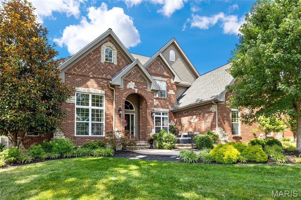 An impressive brick-and-stone elevation introduces this extraordinary 1.5-story residence, where exceptional craftsmanship, timeless elegance, and luxurious living come together seamlessly. A barrel-vaulted foyer welcomes guests and opens to a richly appointed study with custom built-in bookcases, an elegant formal dining room framed by graceful arched entryways, and a breathtaking great room featuring soaring ceilings and a striking cast stone fireplace. Designed for both everyday living and grand entertaining, the gourmet kitchen showcases rich cherry cabinetry, granite countertops, premium appliances, large center island, and abundant workspace. The adjoining breakfast room flows effortlessly into the spectacular vaulted hearth room, where a dramatic floor-to-ceiling stone fireplace creates a warm and inviting gathering space. The luxurious main-level primary suite serves as a private retreat, offering a spa-inspired marble bath with a freestanding soaking tub, oversized walk-in shower with premium spa features, and exceptional custom finishes. Upstairs, three generously sized bedrooms, four full baths, a spacious recreation room, and a dedicated home office provide outstanding comfort, flexibility, and privacy for family and guests. The finished lower level is thoughtfully designed for exceptional entertaining and everyday enjoyment, featuring a custom gathering bar with an adjoining conversation lounge, an expansive family room, fitness studio, private guest suite, and an impressive wine cellar. Perfectly situated on a beautifully landscaped .45-acre lot, the outdoor living spaces are equally exceptional, offering lush gardens, a covered outdoor living room with a fireplace, and an expansive patio designed for relaxing and entertaining. Additional highlights include a whole-house generator, newer driveway, oversized three-car garage with epoxy flooring, and extensive custom cabinetry throughout. Every detail has been carefully considered, creating a residence that seamlessly blends sophisticated design, outstanding amenities, and impeccable craftsmanship into an exceptional luxury living experience.