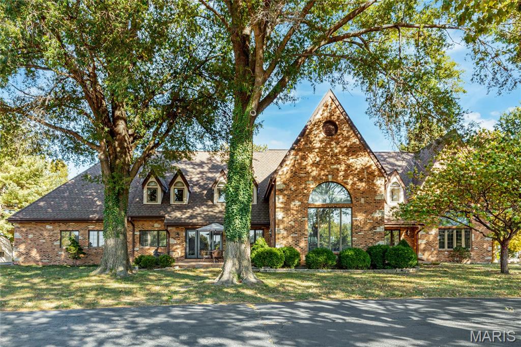 Spectacular brick & stone 1.5 Sty prominently situated on parklike 4-acre grounds adjacent to prestigious Fienup Farms. Impressive 2-sty foyer leads to formal living room, stunning dining room with 20’ beamed cathedral ceiling & marble buffet and vaulted family room with wet bar, floor-to-ceiling fireplace flanked by built-in bookcases & atrium doors that open to terrace. Custom-designed kitchen with solid surface countertops, commercial grade appliances & 9’ center island adjoins light-filled breakfast room with convenient planning center. Primary bedroom suite with 2 walk-in closets & luxury bath with jetted tub plus a private office complete the main floor living quarters. Front & rear staircases access 3 additional bedrooms, 1 with ensuite bath, bonus room & hall full bath. Expansive Lower Level includes game room (framed & ready for finish) & ample storage space. Extensively landscaped lot with mature trees, paver terrace, 2 patios, utility shed & oversized 3-car garage.