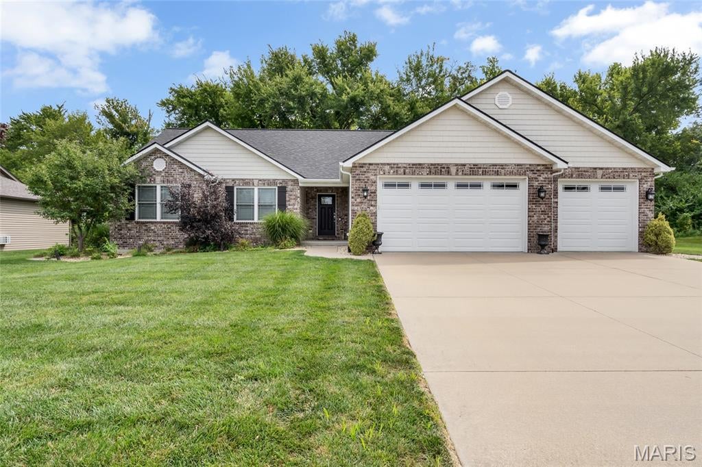 Welcome to this stunning 4-bedroom, 3-bathroom home perfectly situated in Columbia, IL! With its beautiful brick veneer front, vinyl siding, and lovely landscaping creating exceptional curb appeal, this home makes a wonderful first impression before you ever step inside.

The spacious and inviting family room is the true heart of this home, featuring a soaring vaulted ceiling, an elegant open spindle staircase, abundant natural light, and a cozy fireplace — the perfect gathering spot for family and friends. The family room flows seamlessly into the dining area, which is highlighted by sliding glass doors that open to the lovely patio overlooking the fully fenced backyard, a peaceful and private retreat shaded by beautiful mature trees, perfect for outdoor entertaining and relaxing evenings at home.

The well-appointed kitchen is sure to impress, boasting stunning granite countertops, custom cabinetry, and a breakfast bar, combining style & functionality for everyday living and entertaining. The luxurious primary bedroom suite is a true retreat, featuring a vaulted ceiling, a spacious walk-in closet, and a private attached bathroom complete with a soaking tub and separate shower. Two additional generously sized bedrooms, a second full bathroom, and a dedicated laundry room round out the main level, providing everything you need for comfortable, convenient everyday living.

The finished lower level significantly expands your living space, boasting a sprawling recreation room perfect for entertaining, movie nights, and game days, along with a fourth bedroom and third full bathroom — ideal for guests, a private retreat, or a dedicated home office.

Step outside and enjoy the beautiful patio overlooking the fully fenced backyard, surrounded by stunning mature shade trees that create a serene and private outdoor oasis perfect for relaxing and entertaining year-round.

With its stunning curb appeal, thoughtful layout, beautiful finishes, and wonderful outdoor living spaces, this lovely home is a truly exceptional find in Columbia.