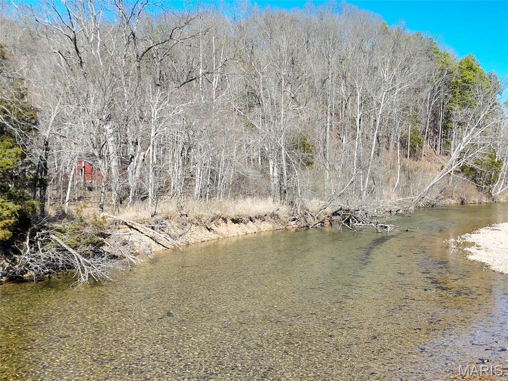 49.5+- acres of wooded land offering privacy, recreation, and excellent potential for a future getaway. The property features predominantly flat terrain and a natural setting, with beautiful frontage along the crystal-clear waters of 12 Mile Creek. A year-round, spring-fed creek known for its gravel bottom and crystal clear water perfect for fishing, swimming or just relaxing along the water’s edge. This tract provides excellent wildlife habitat and an open corridor serving as a shooting lane or could be developed into a food plot for wildlife. With electric crossing the property and convenient road frontage for easy access, this land offers great possibilities for campsites or a future cabin location while maintaining a secluded feel. Offered separately from the larger 63-acre tract this presents a rare chance to own a substantial recreational property along one of the region’s most desirable year-round creeks.