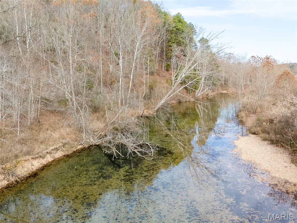 49.5± acres of wooded land offering privacy, recreation, and excellent potential for a future getaway. The property features predominantly flat terrain and a beautiful natural setting, with frontage along the crystal-clear waters of 12 Mile Creek. This year-round, spring-fed creek features a gravel bottom and clear water, perfect for fishing, swimming, or simply relaxing along the water’s edge. The property provides excellent wildlife habitat, along with an open corridor that serves as a natural shooting lane or could be developed into a food plot for wildlife. A new electric line is being run across the property, providing easier access to power and giving you more options when choosing a location for a future cabin, home, or campsite. With convenient road frontage for easy access and plenty of room to explore, this property offers an excellent combination of privacy, recreation, and future possibilities along one of the region’s most desirable year-round creeks.
